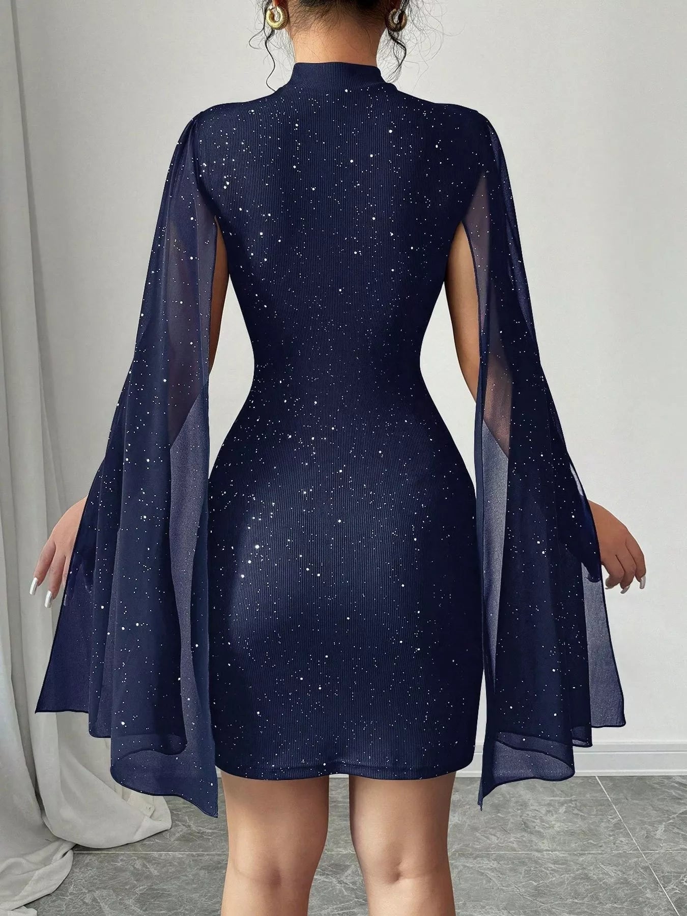 Cutout Bodycon Mini Dress with Cape Sleeves; navy glitter fabric with sheer cape sleeves (back view)