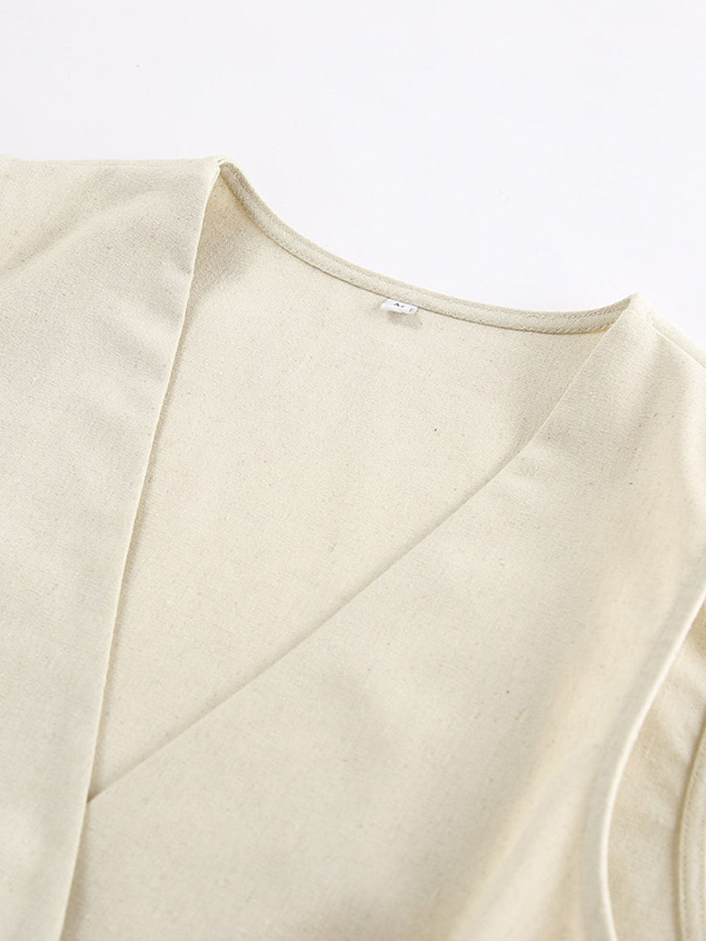 Button Up Vest and Shorts Set beige fabric close-up neckline detail.