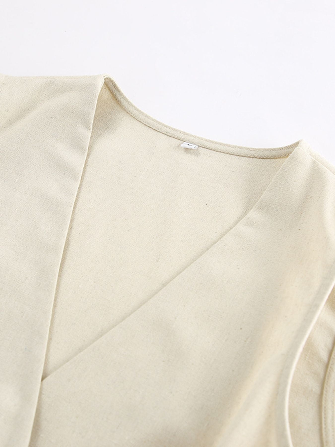 Button Up Vest and Shorts Set beige fabric close-up neckline detail.