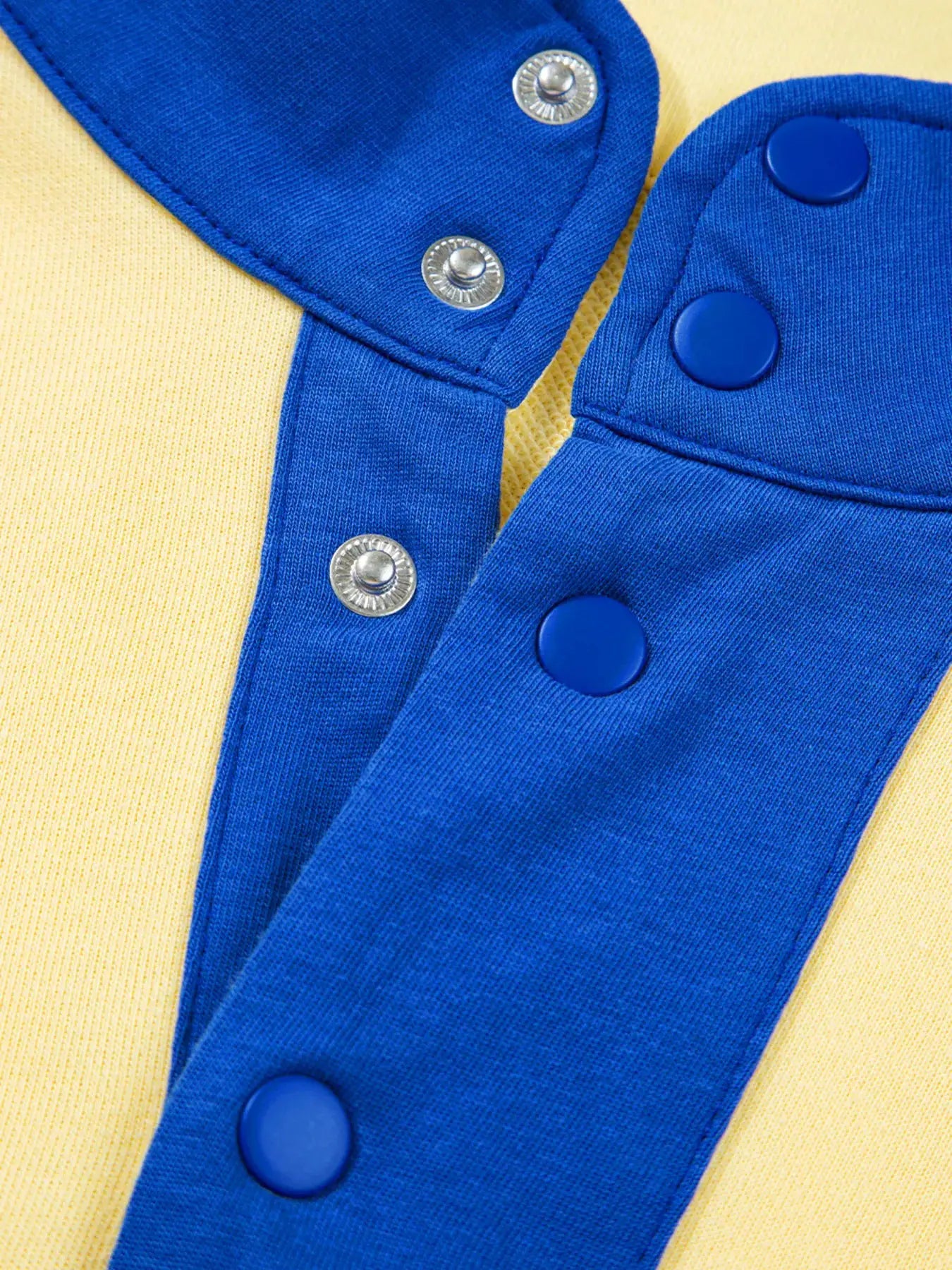 Color block activewear top and shorts set in blue over yellow fabric with blue snap buttons
