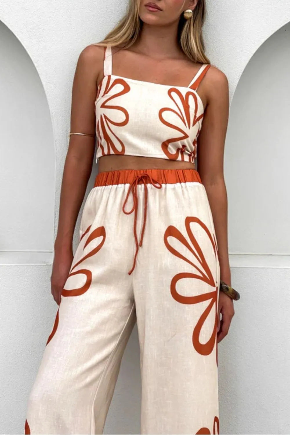 Smocked square-neck cami and pants set in cream with rust-orange floral print; wide-leg pants with drawstring waist