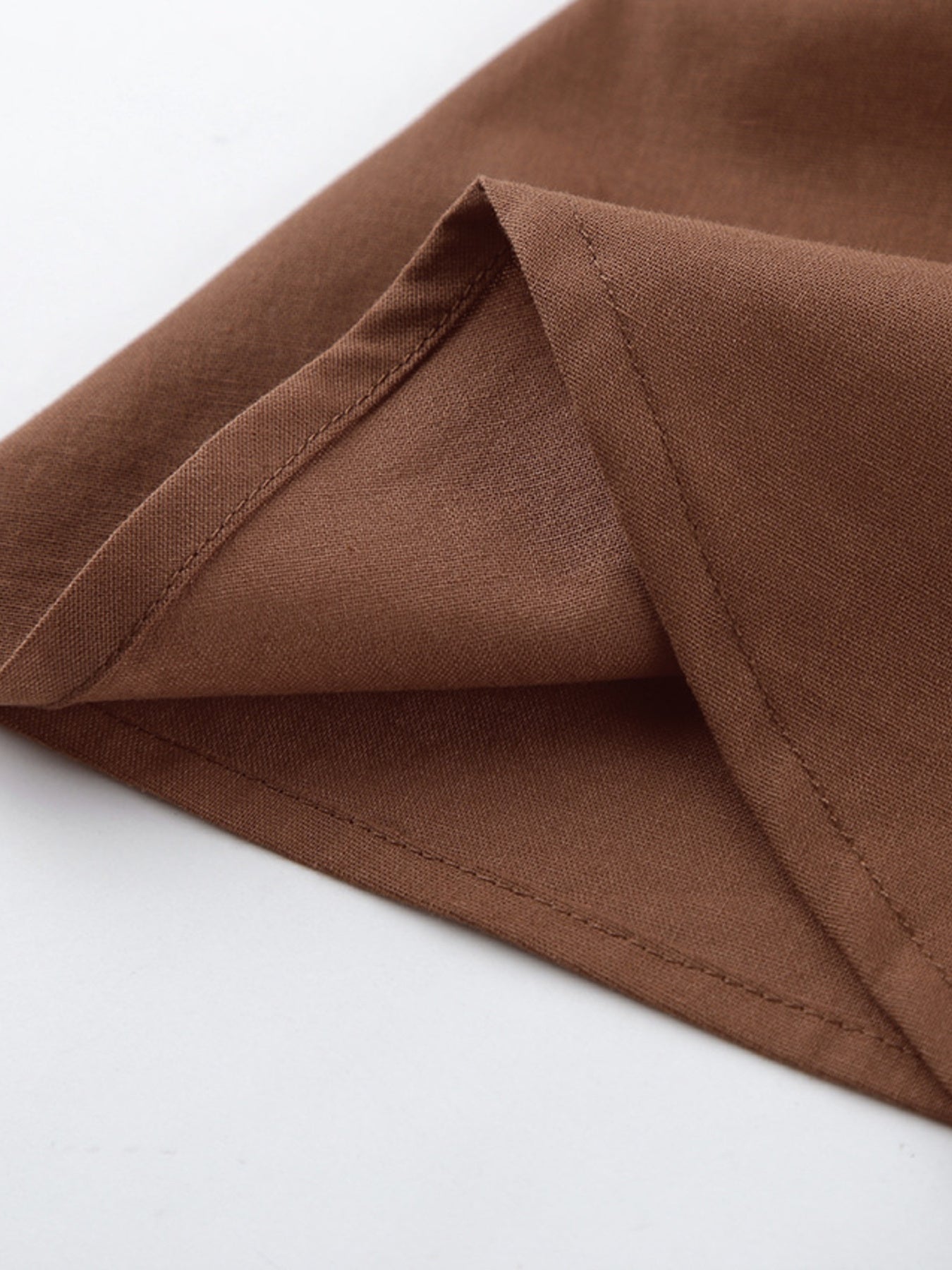Belle Bijouix One-Shoulder Top and Shorts Set in brown fabric with ruched, asymmetrical details.