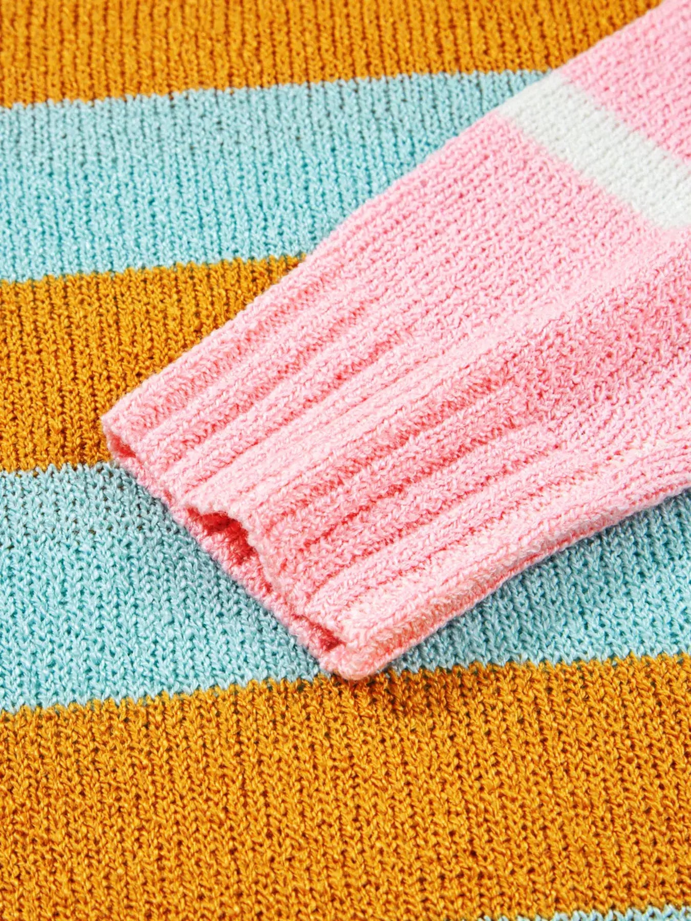 Color block striped knit sweater with pink ribbed cuff and orange teal stripes