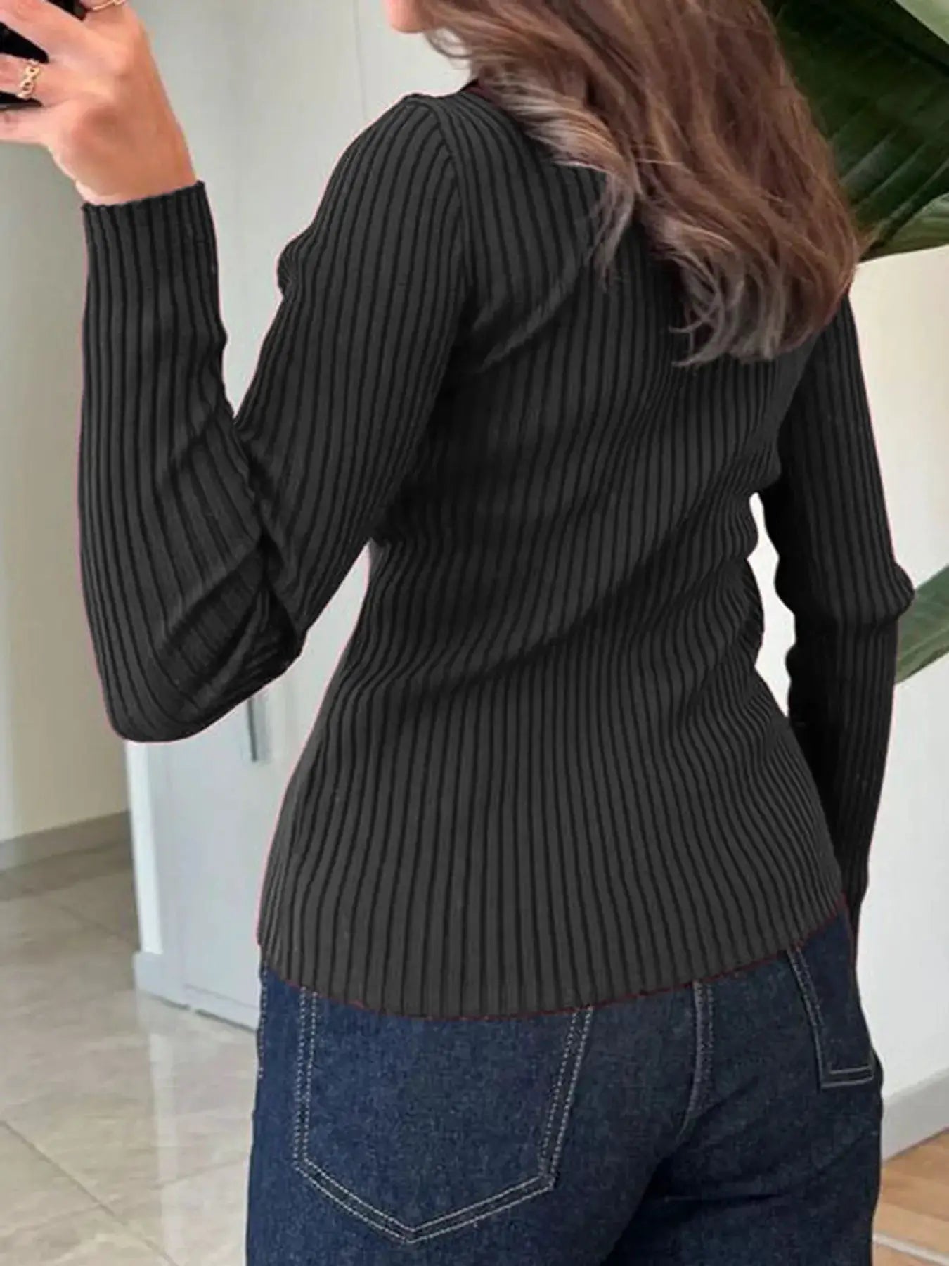 Ribbed button-front long-sleeve cardigan in black knit, shown from back with blue denim jeans