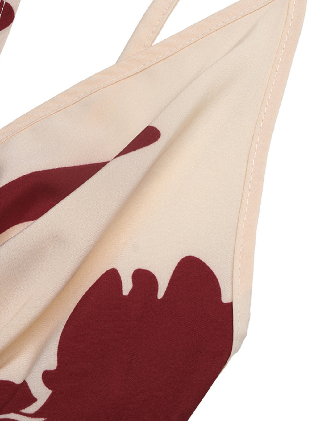 Deep V-neck spaghetti-strap maxi dress in beige with bold red floral print.