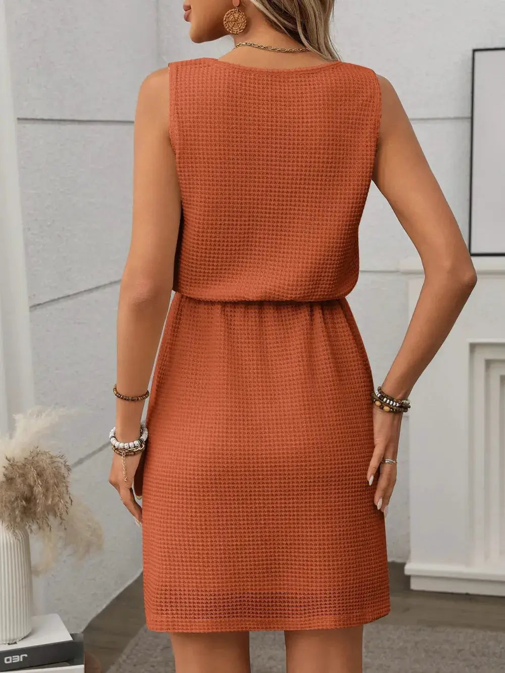 Waffle-knit mini tank dress in rust orange, sleeveless with a defined waist seam