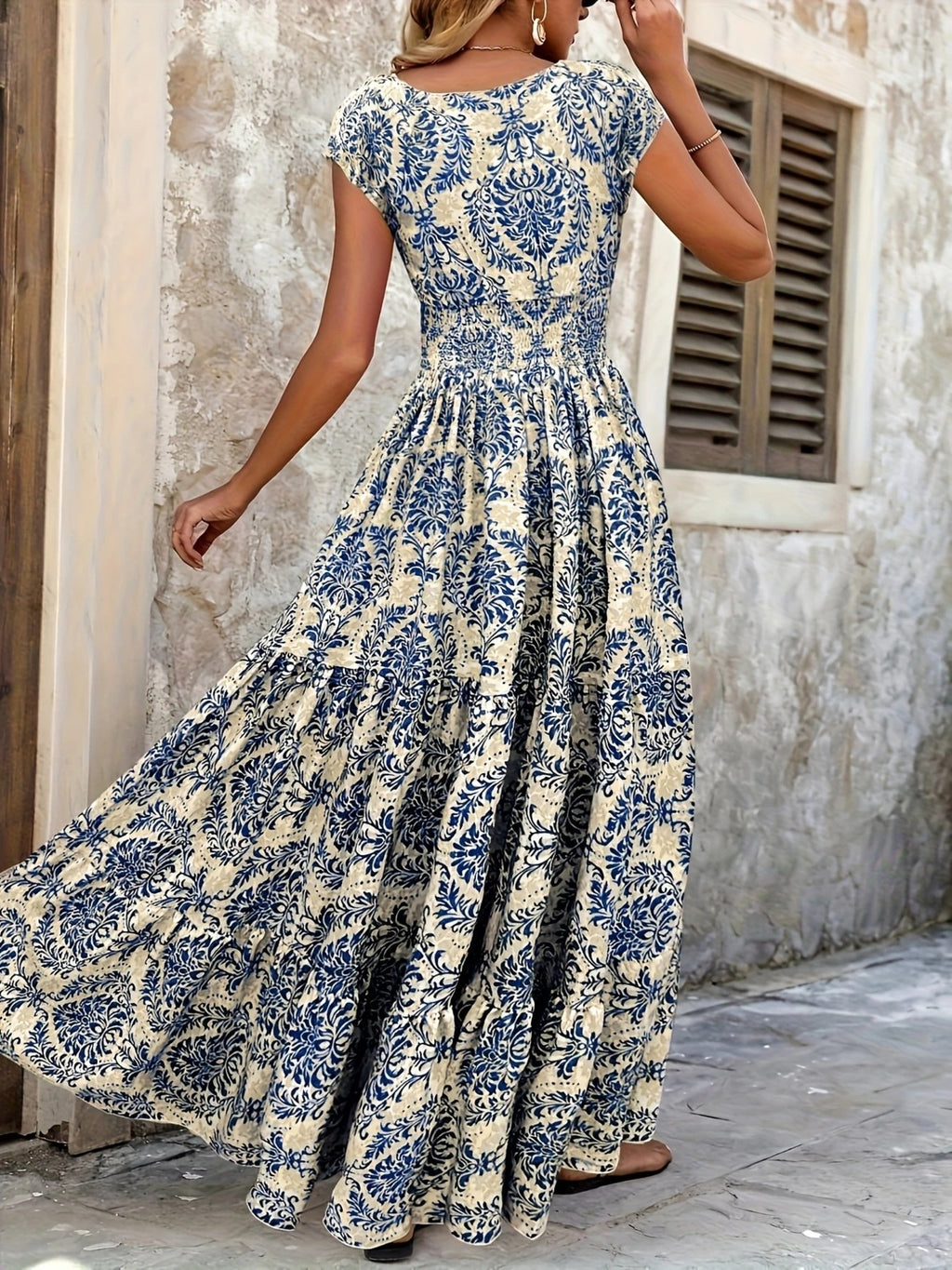 Printed cap-sleeve maxi dress in cream with navy floral print; smocked waist and tiered skirt.