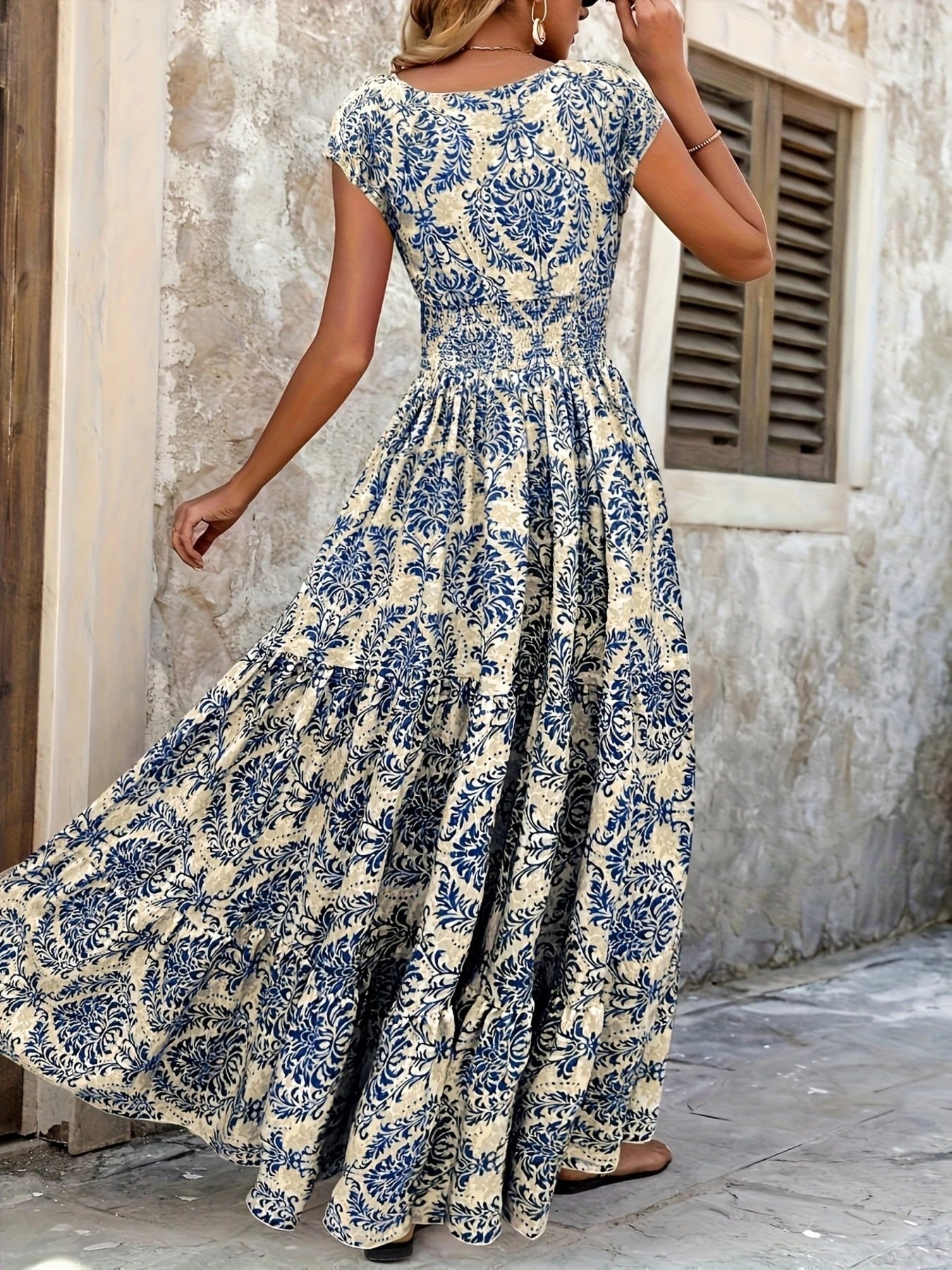 Printed cap-sleeve maxi dress in cream with navy floral print; smocked waist and tiered skirt.