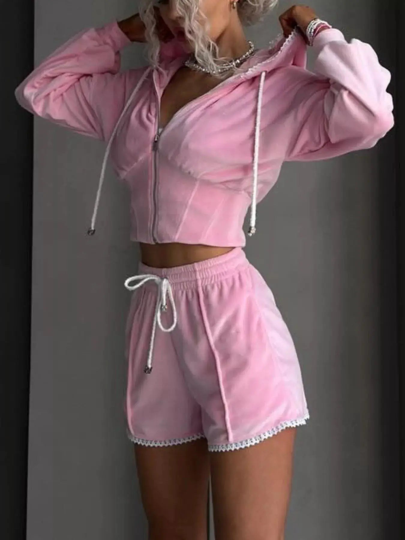 Belle Bijouix pink two-piece zip-up hooded activewear set with shorts, white drawstrings, lace-trimmed hems.