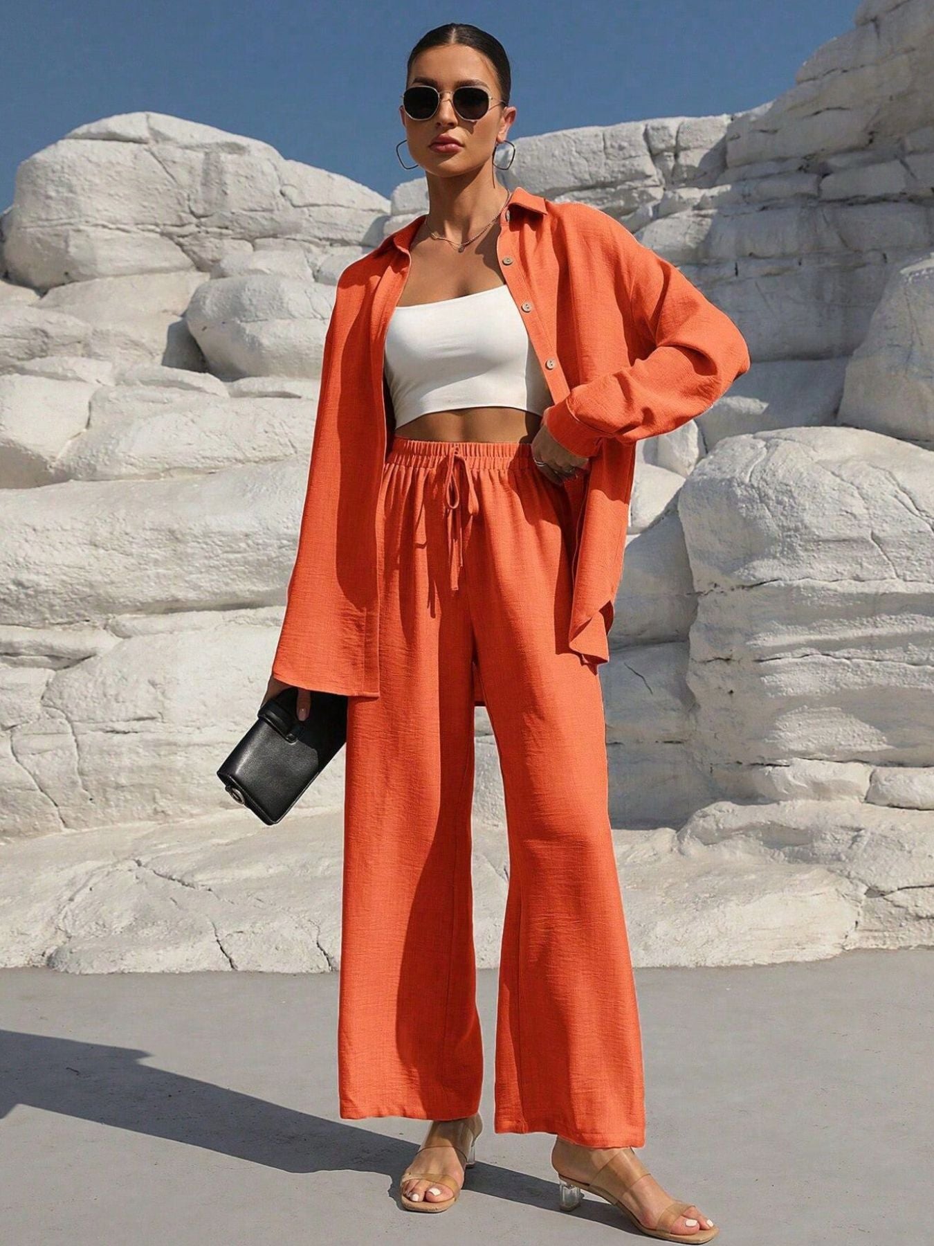 Button Up Long Sleeve Shirt and Pants Set by Trendsi in orange; model wears a white crop top.