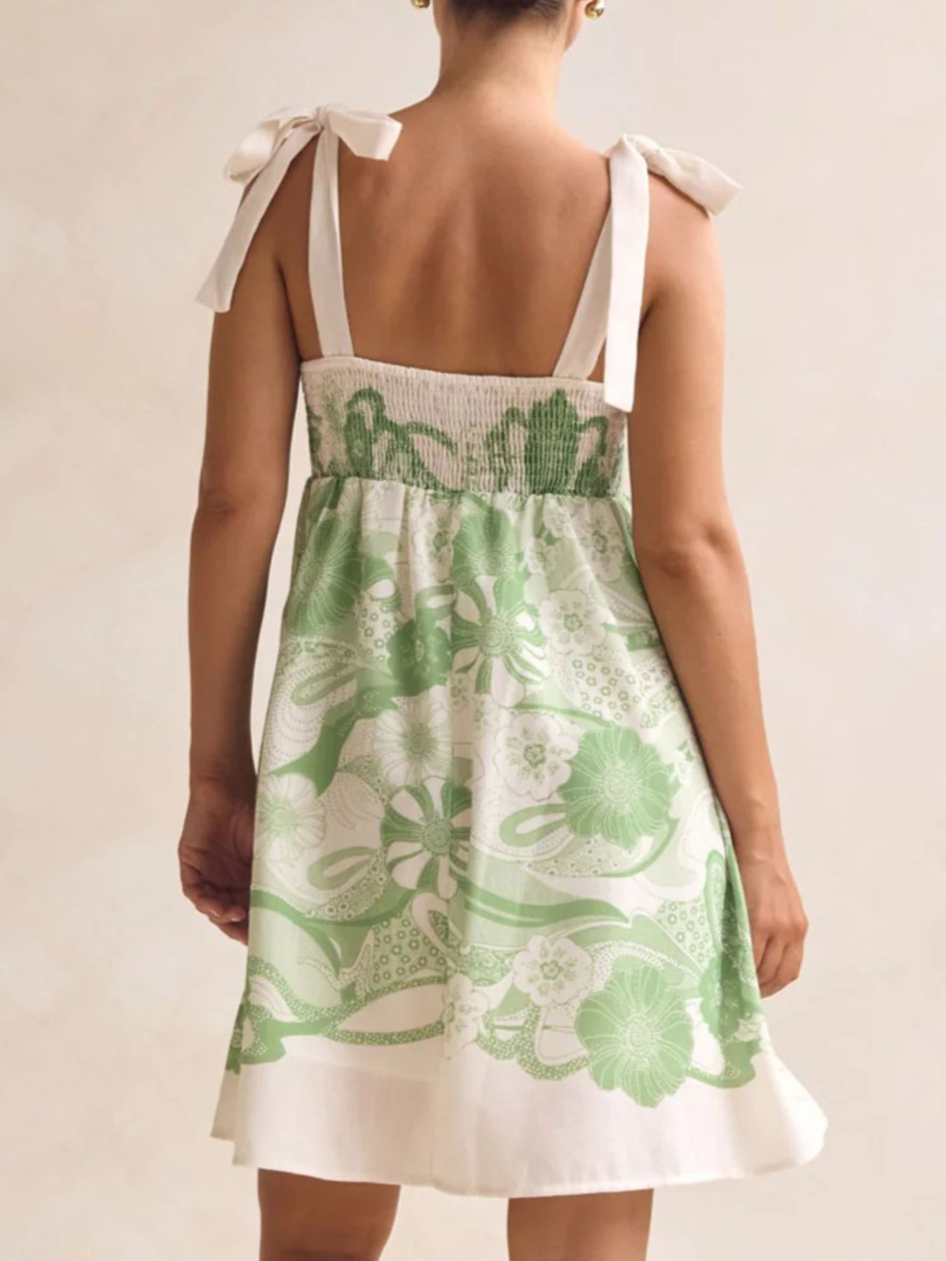 Printed tie-shoulder mini dress in green floral print with smocked bodice by Belle Bijouix