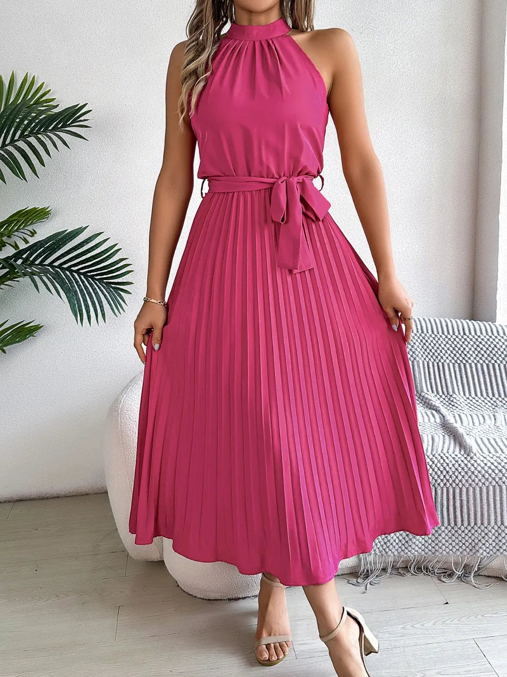 Pleated tie-waist sleeveless midi dress in magenta with high neckline and flowing skirt perfect for weddings and events