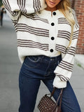 Striped button-down knit cardigan in white with brown stripes, black buttons, paired with dark jeans.