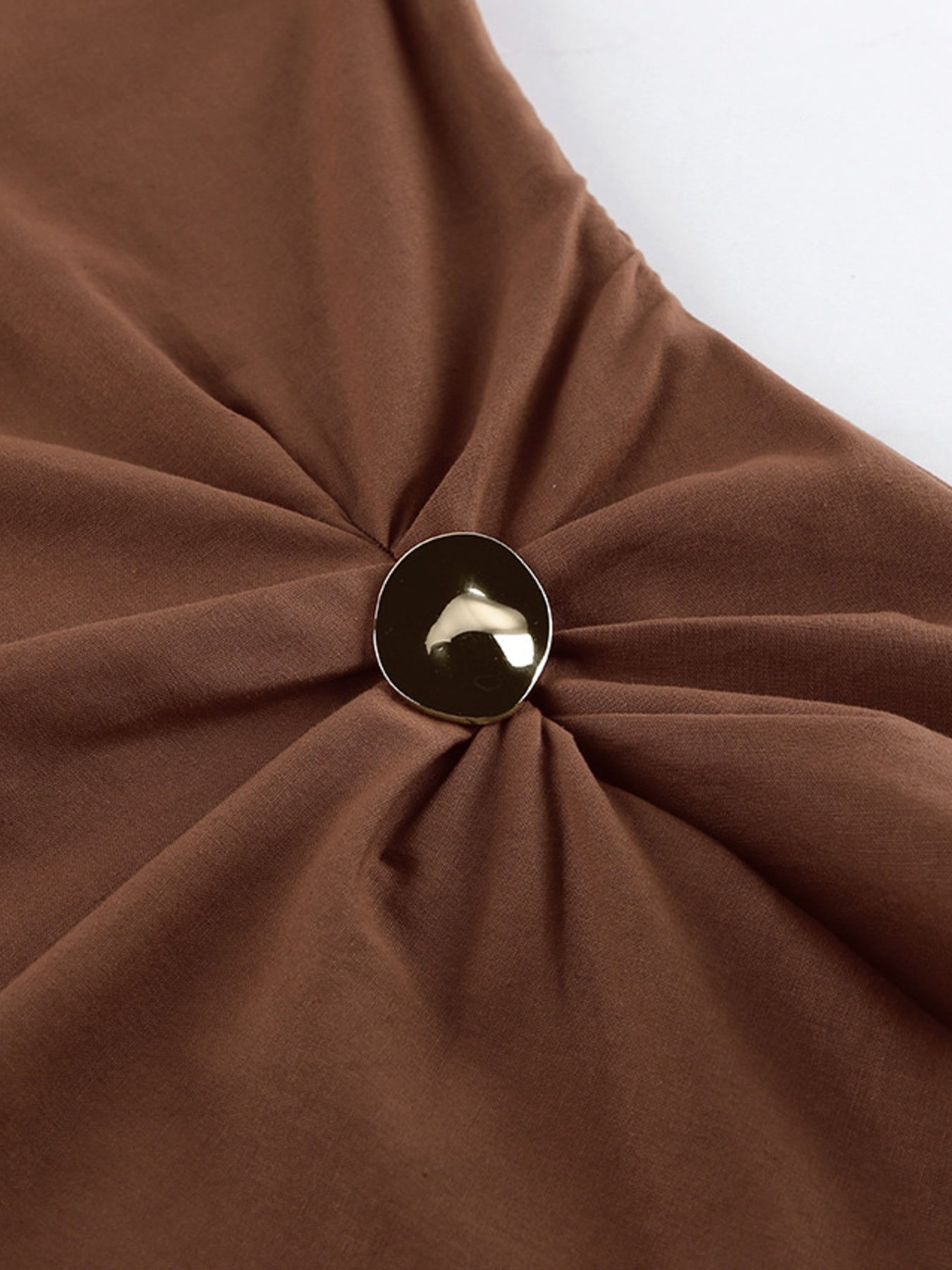One-Shoulder Top and Shorts Set in brown fabric with a twisted knot and gold-tone round clasp
