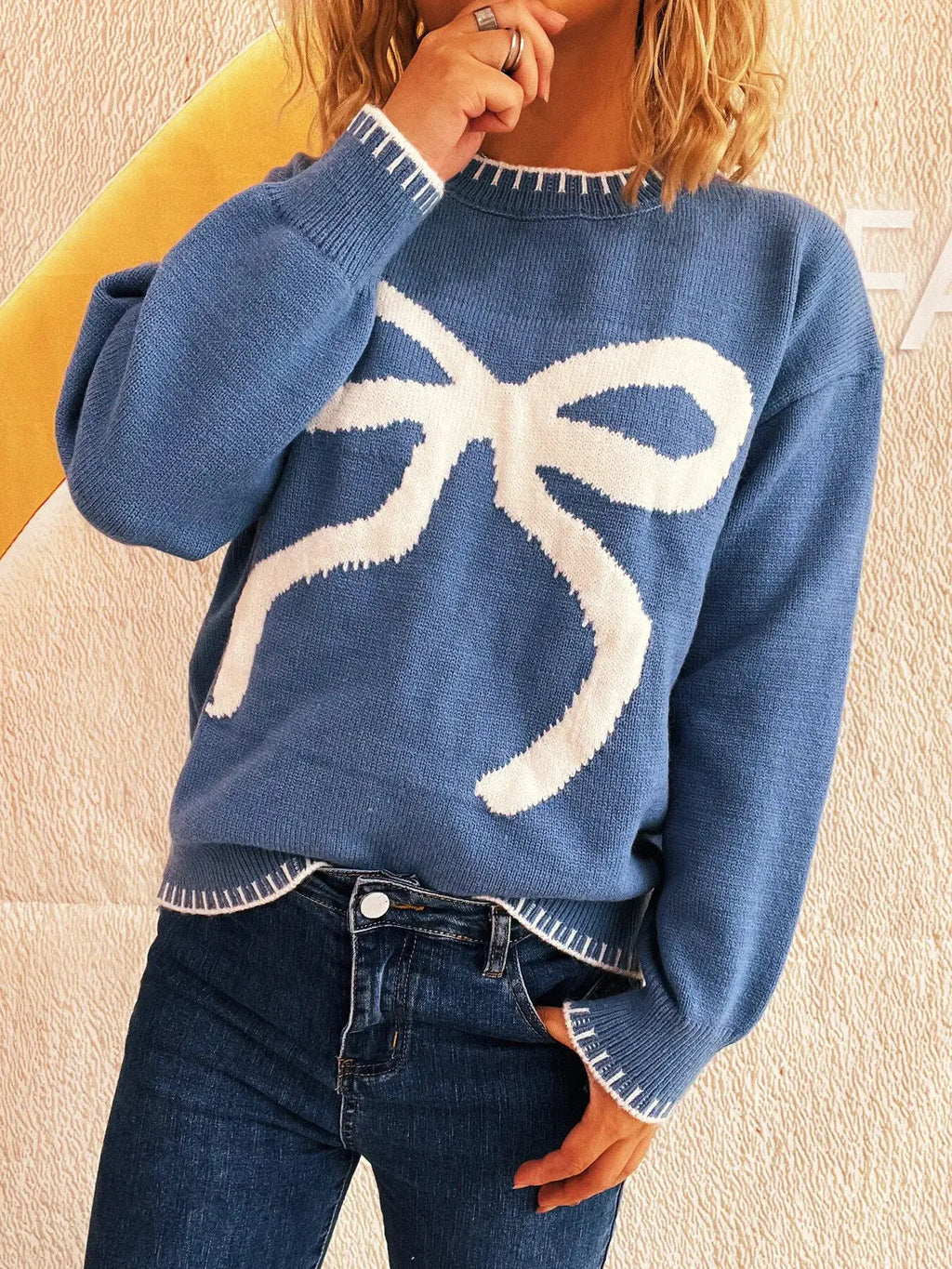 Bow Pattern Round Neck Sweater in blue with white bow graphic and ribbed cuffs and hem