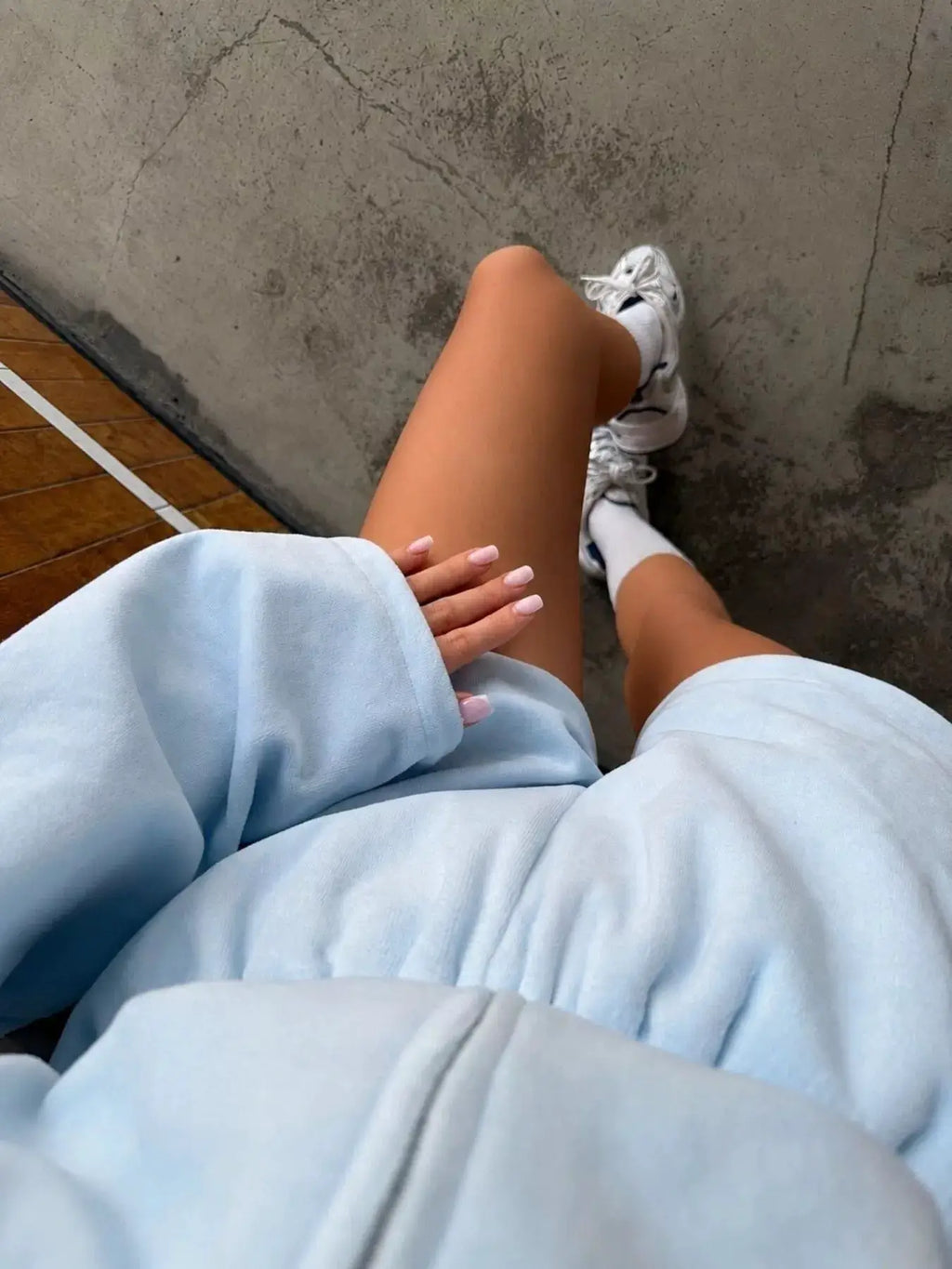 Belle Bijouix women's activewear two-piece set in light blue: long-sleeve zip hoodie and shorts, with white sneakers.