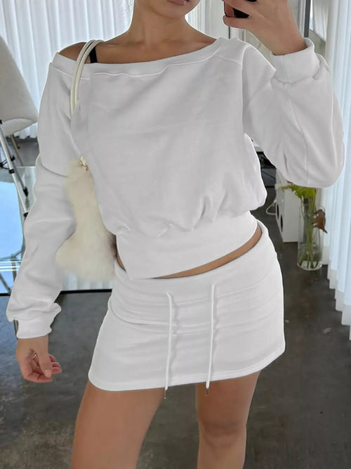 White boat-neck sweatshirt and mini skirt set, active wear; cropped top with long sleeves, drawstring waist and slit detail.