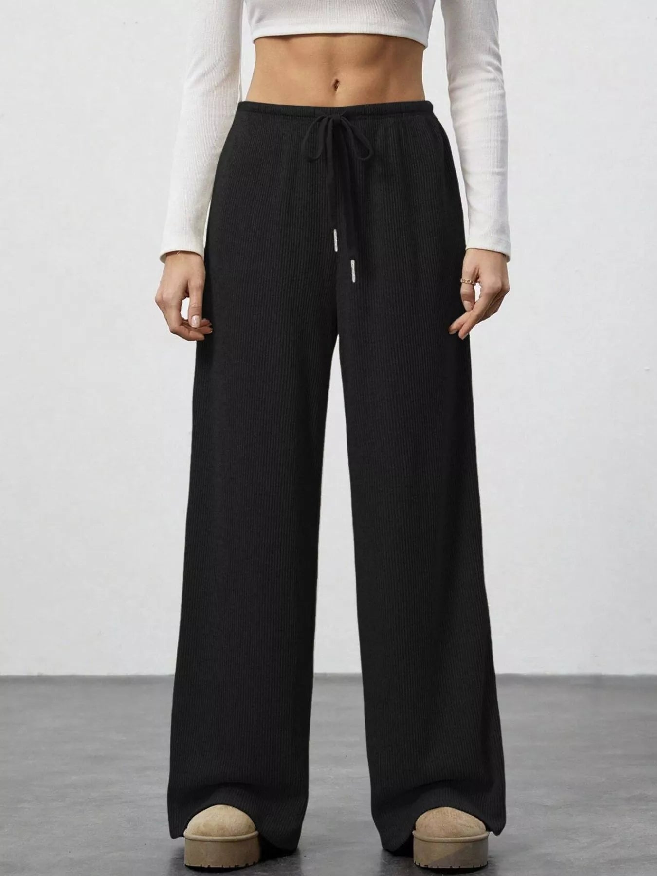 Relaxed fit drawstring pants in black ribbed knit with pockets, active wear joggers.