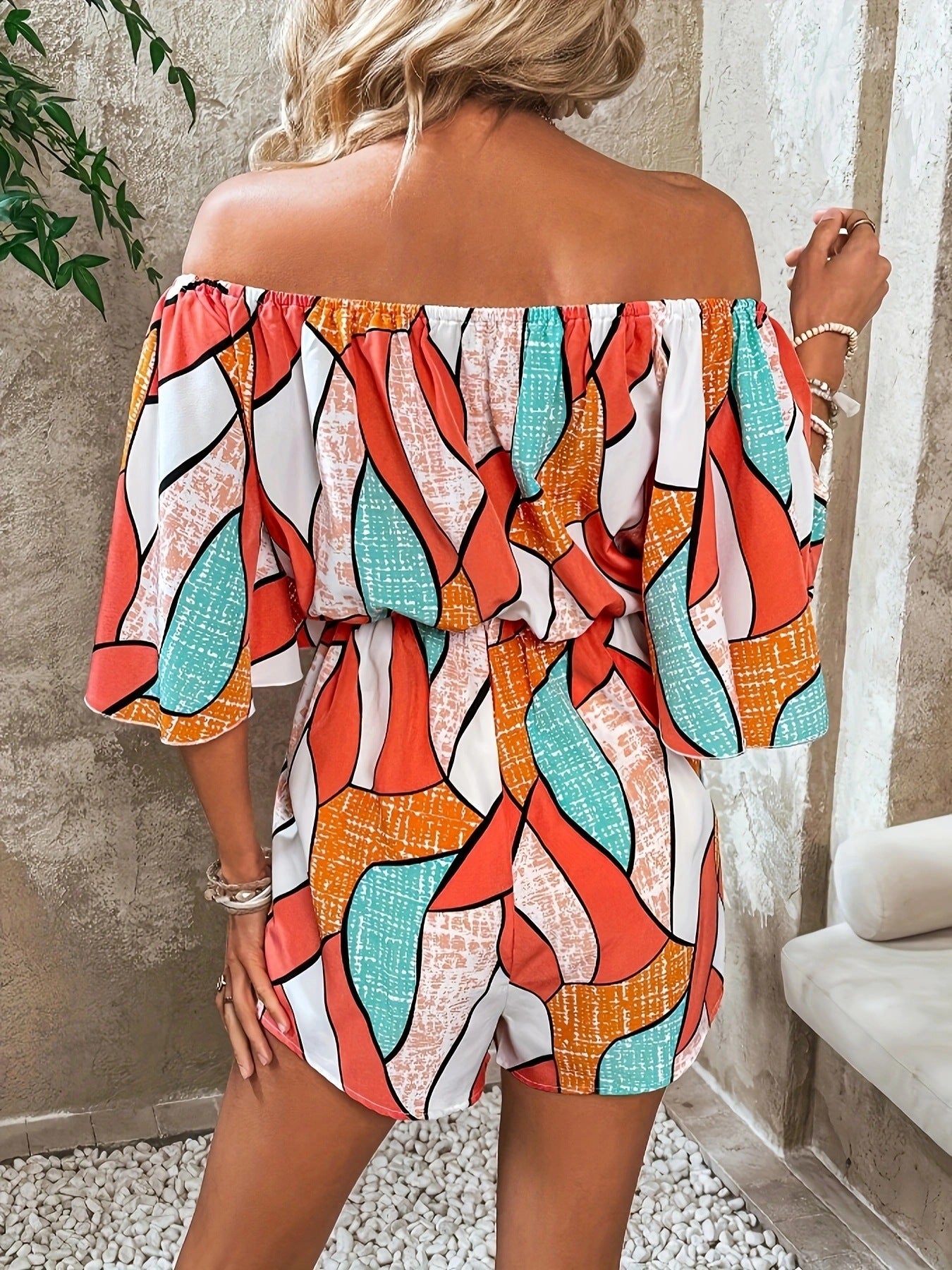 Off-shoulder drawstring waist romper in orange, teal, and white geometric print