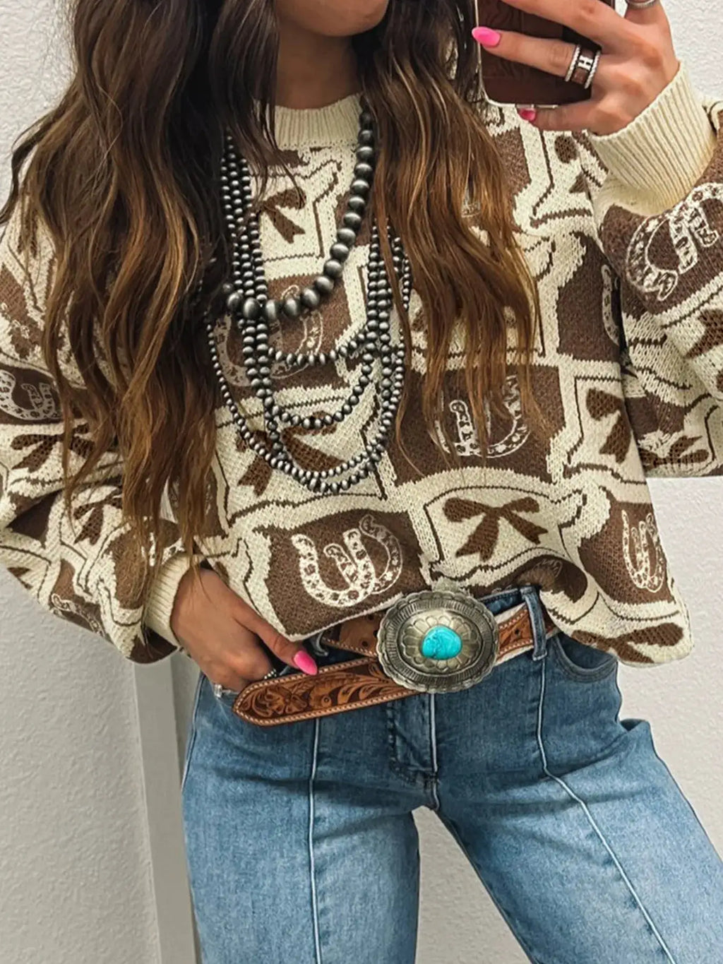 Graphic Round Neck Long Sleeve Sweater in beige-brown knit with bold pattern, styled with blue jeans.