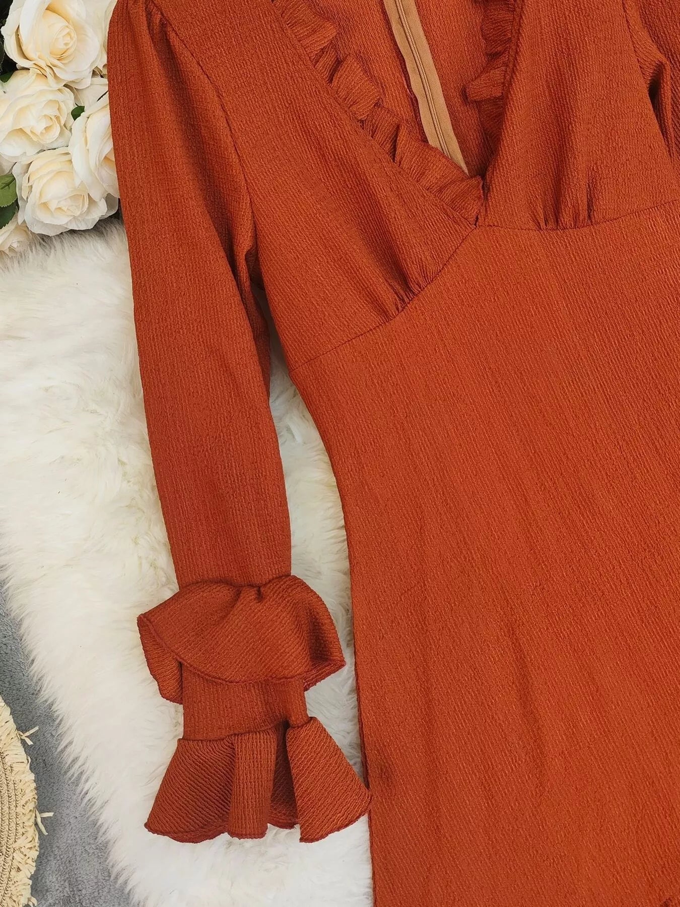 Ruffled High-Low Long Sleeve Dress in rust orange; textured fabric with frill details and gathered cuffs.