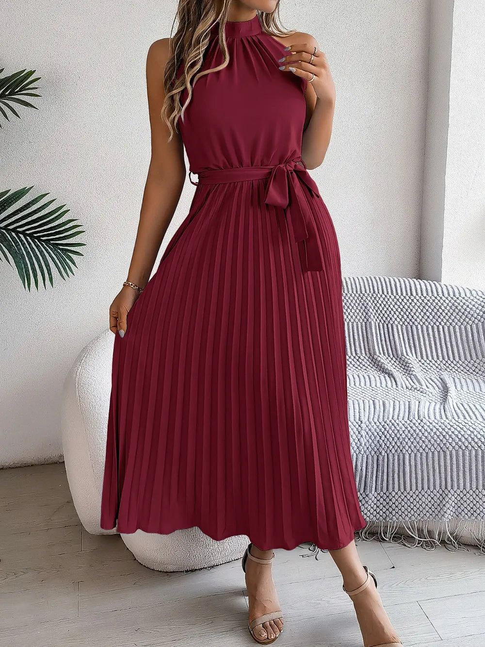 Pleated tie-waist sleeveless burgundy midi dress; chic, mid-calf length.