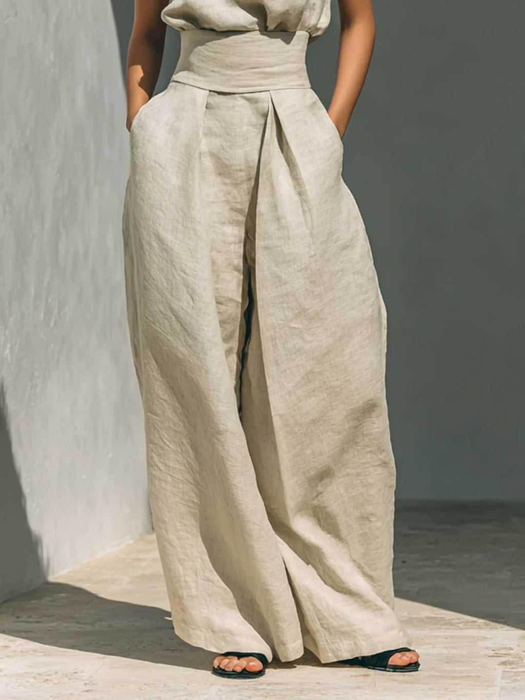 Turtleneck sleeveless top and pants set in beige linen with wide-leg front-pleat wrap pants