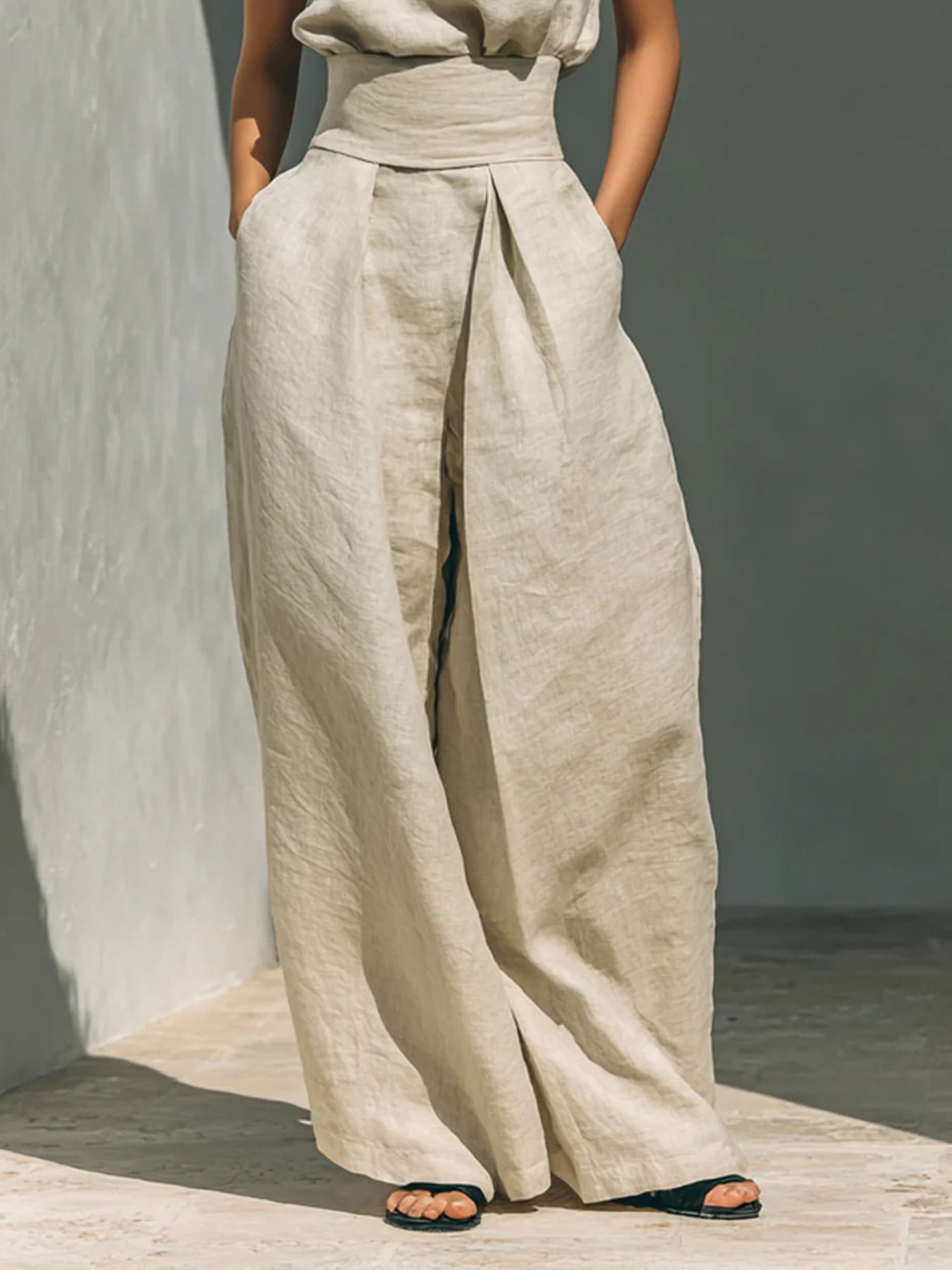 Turtleneck sleeveless top and pants set in beige linen with wide-leg front-pleat wrap pants