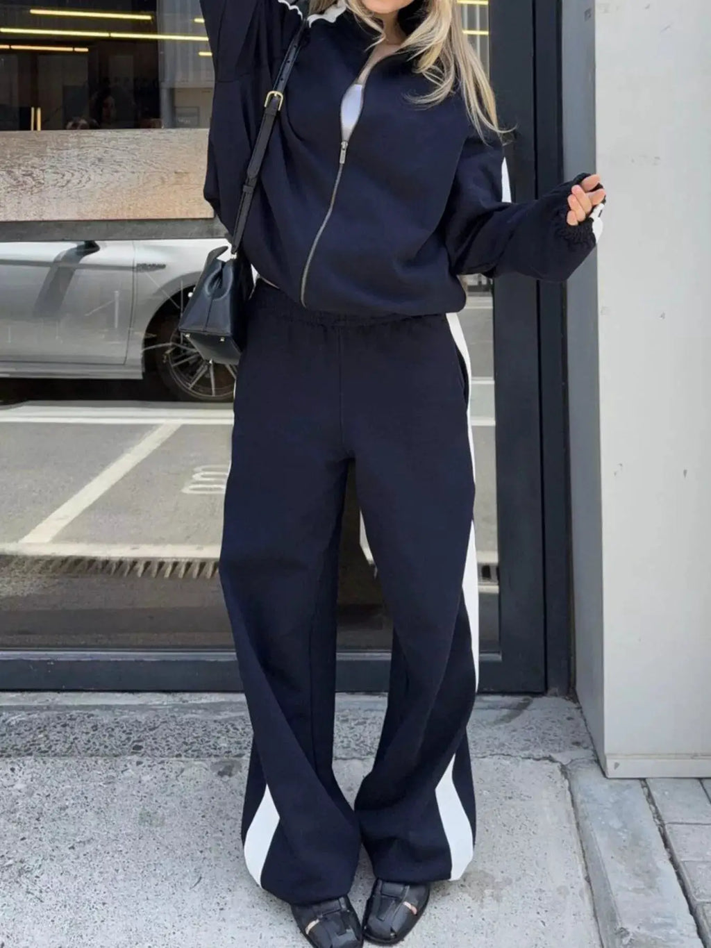 Two-piece zip-up activewear set by Belle Bijouix in navy with white side stripes