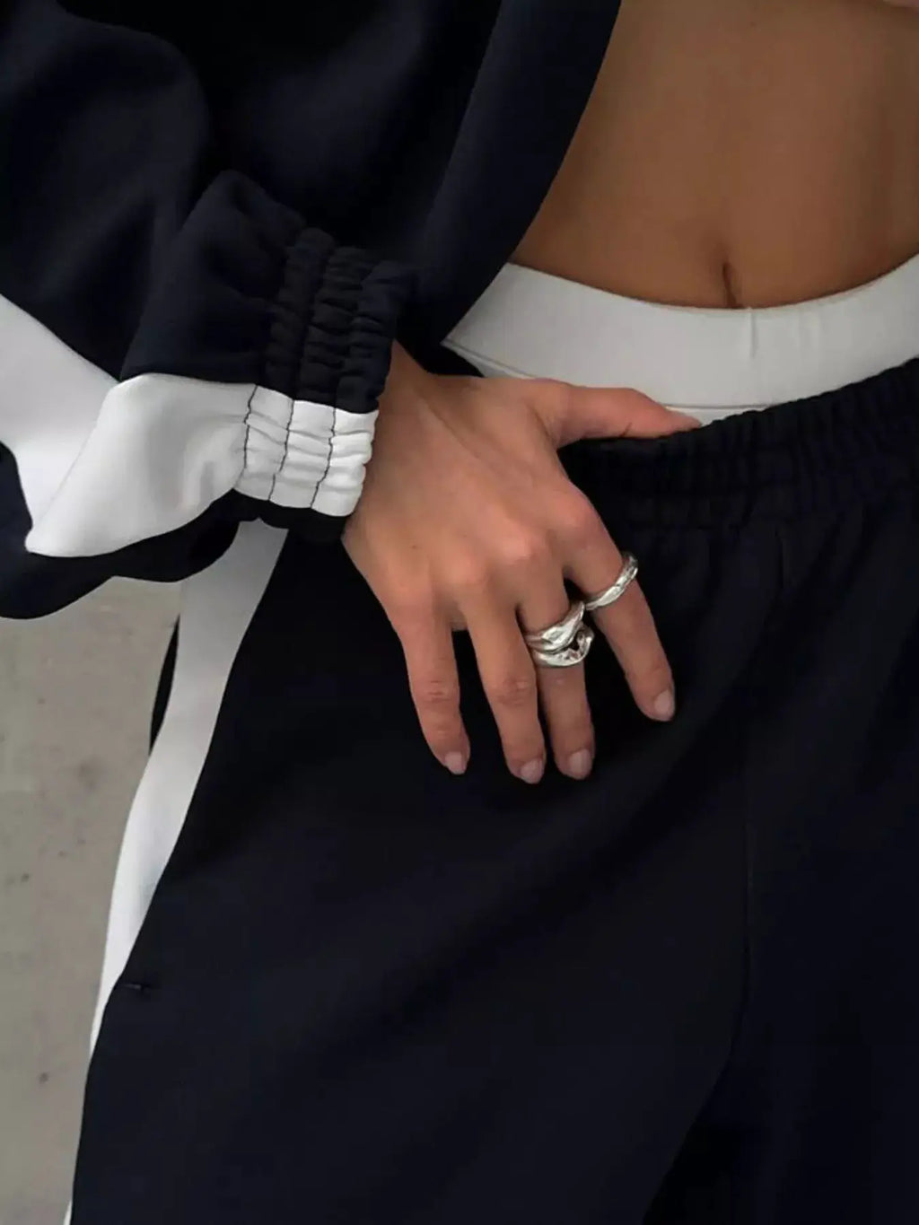 Belle Bijouix two-piece zip-up long-sleeve activewear set in black with white cuffs and waistband (top + pants)