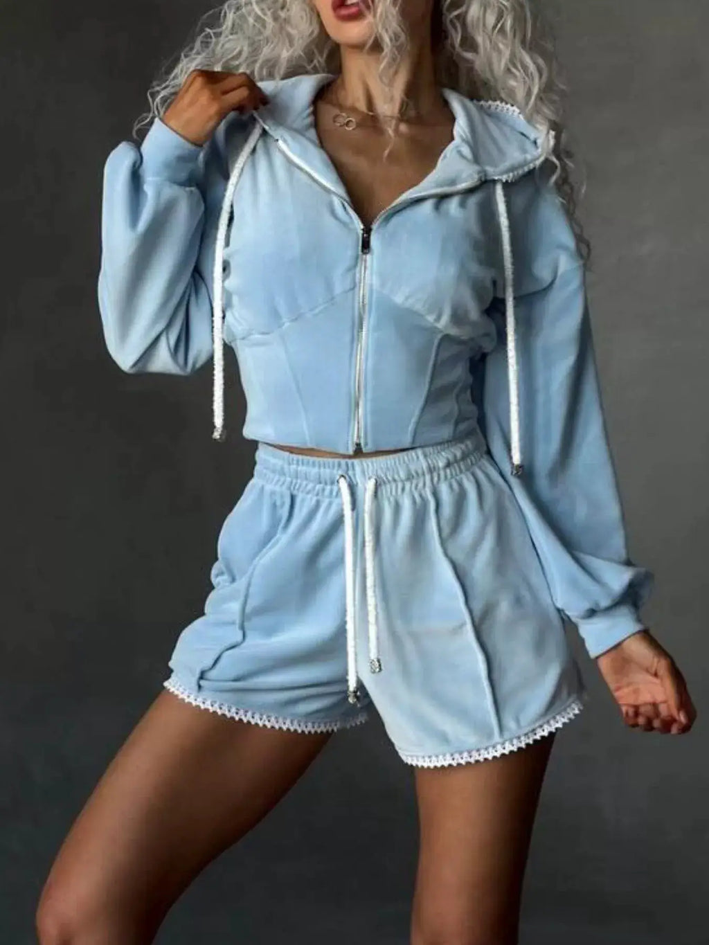 Two-piece light blue zip-up hooded activewear set with matching shorts, white drawstrings and crochet-trim hems.