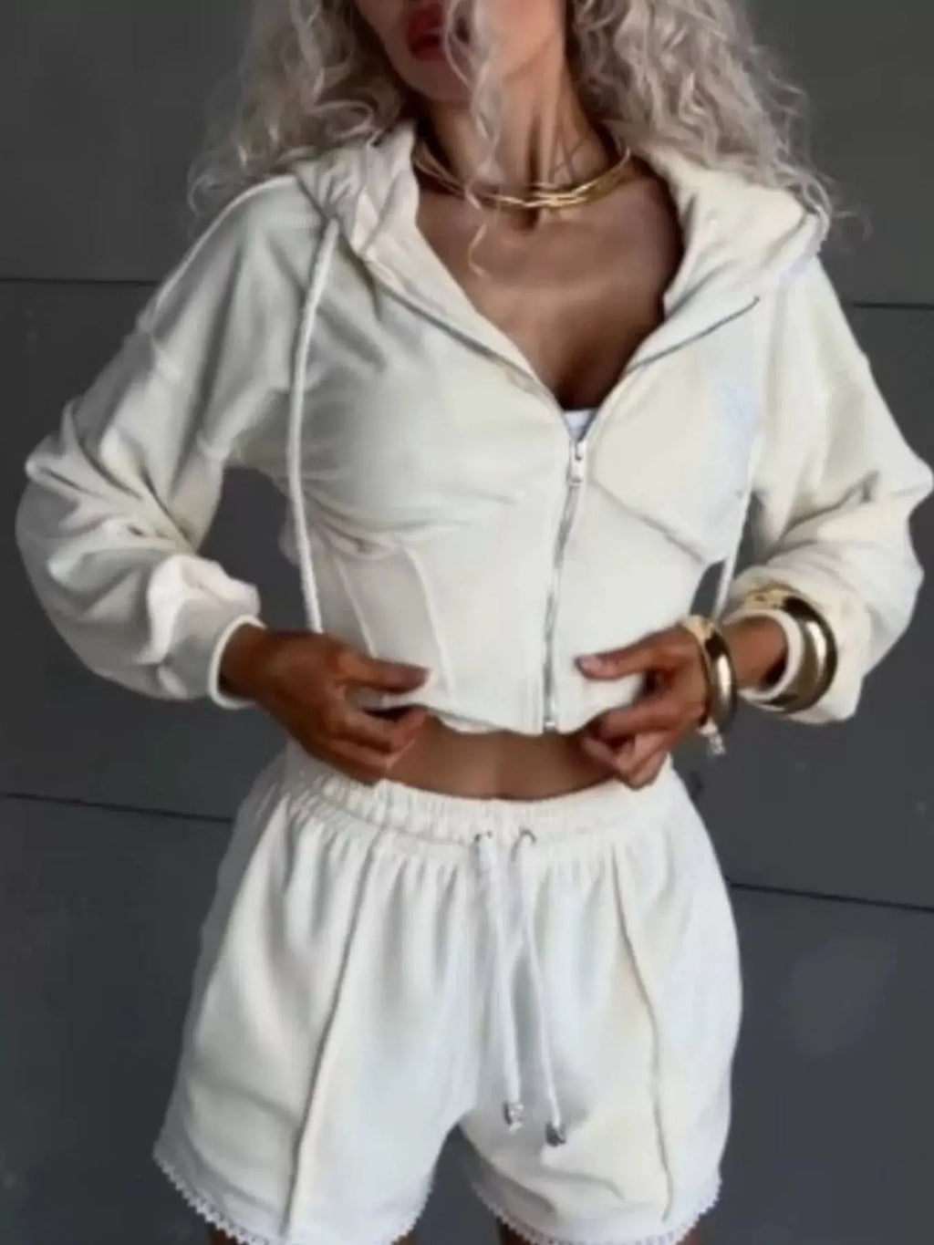 Zip-up white hooded jacket and matching shorts; two-piece activewear set.
