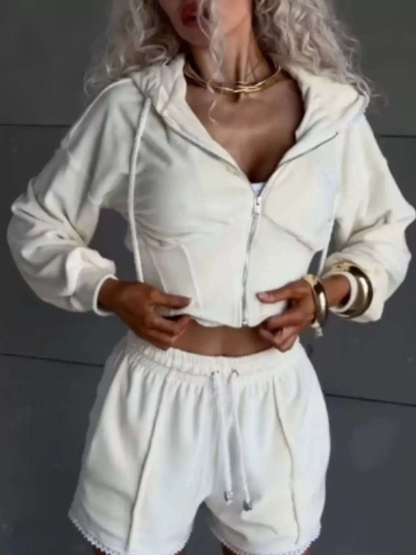 Zip-up white hooded jacket and matching shorts; two-piece activewear set.