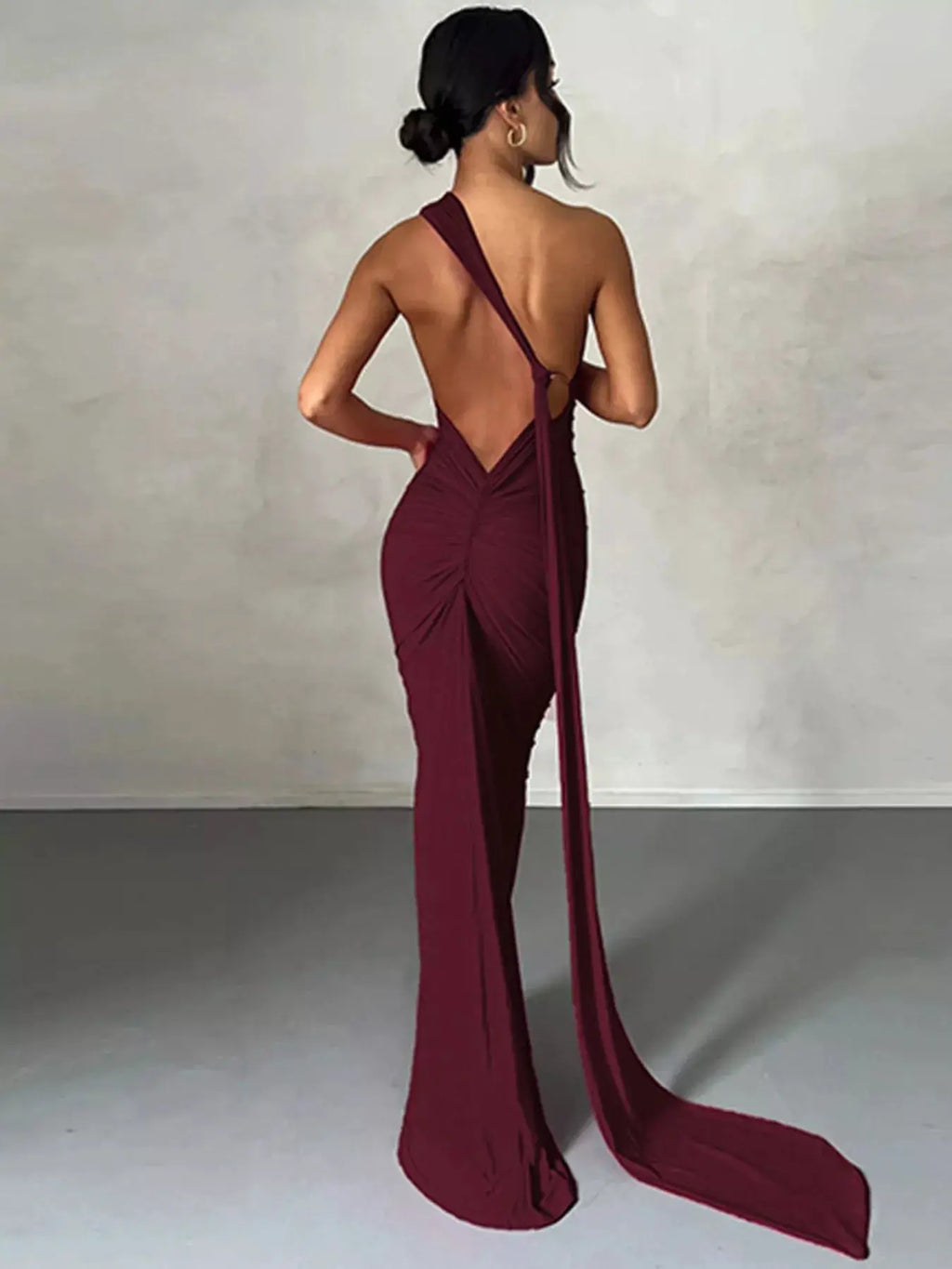 Backless One-Shoulder Ruched Bodycon Maxi Dress in burgundy with center ruching and long train.