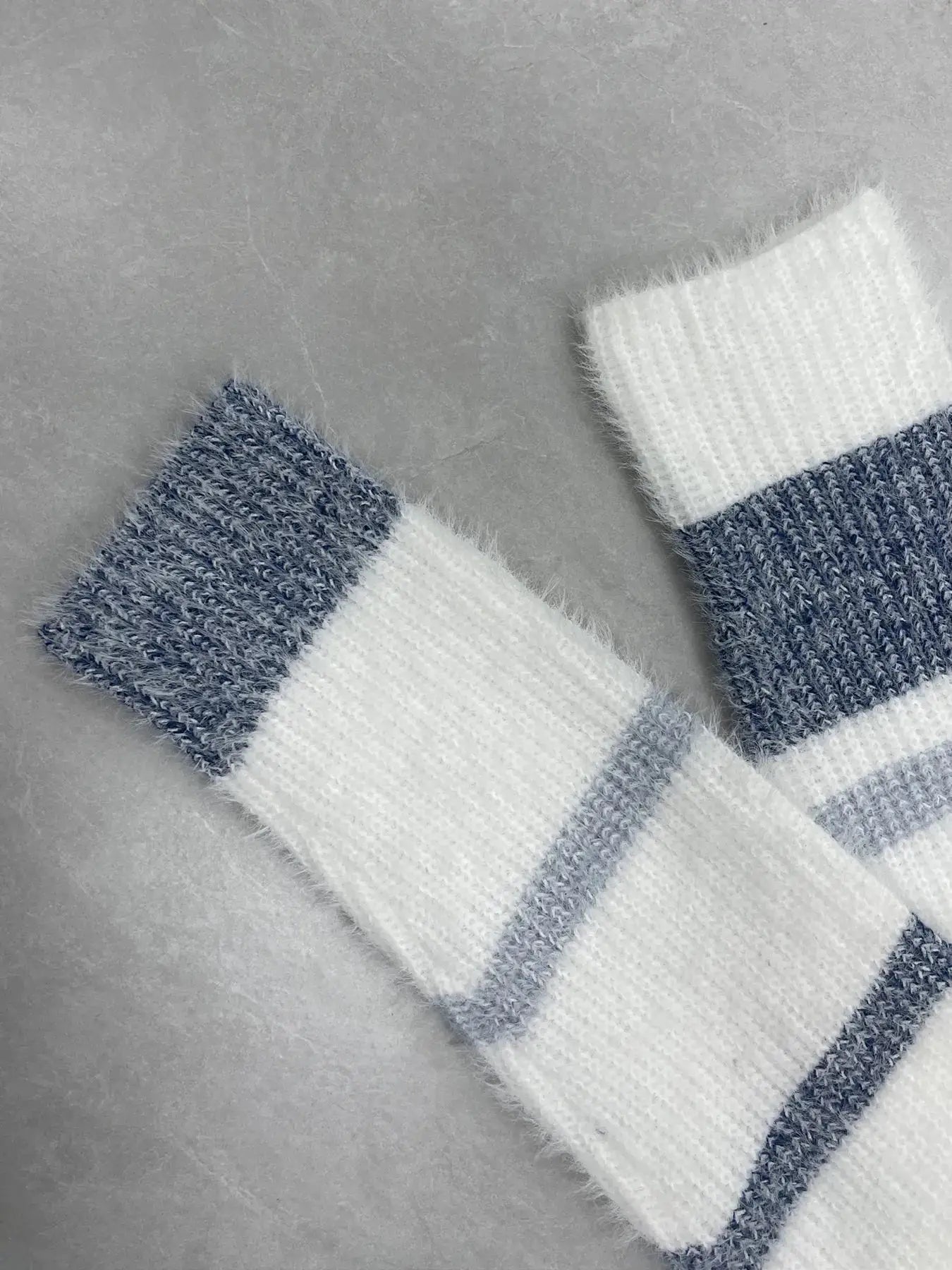 Striped fuzzy knit sweater with blue and white bands; long-sleeve.