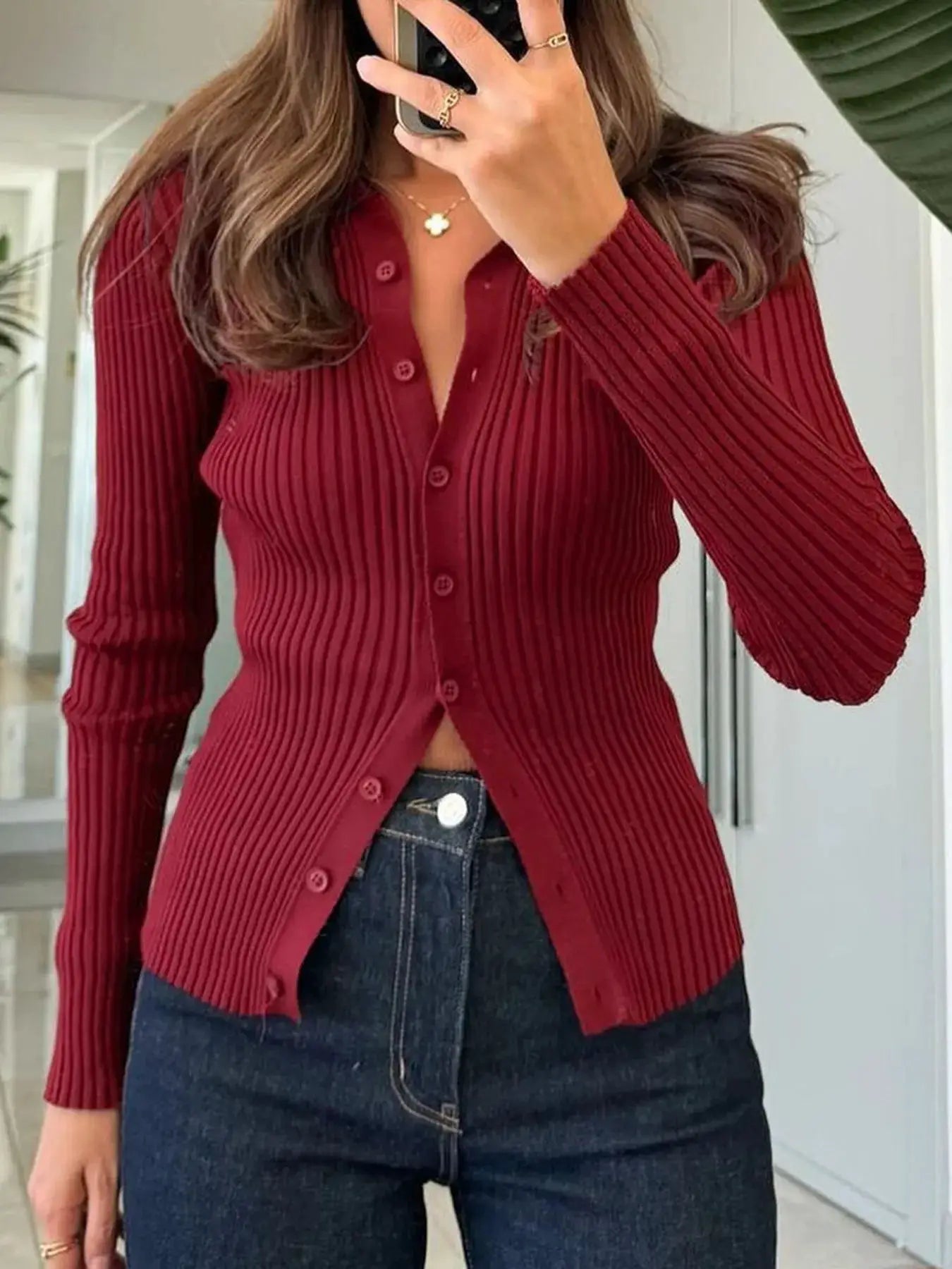 Ribbed button-front long-sleeve cardigan in burgundy knit, worn with dark jeans.