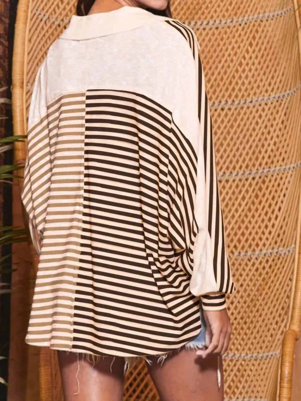 Striped oversized half-button sweatshirt top; black and white stripes, back view