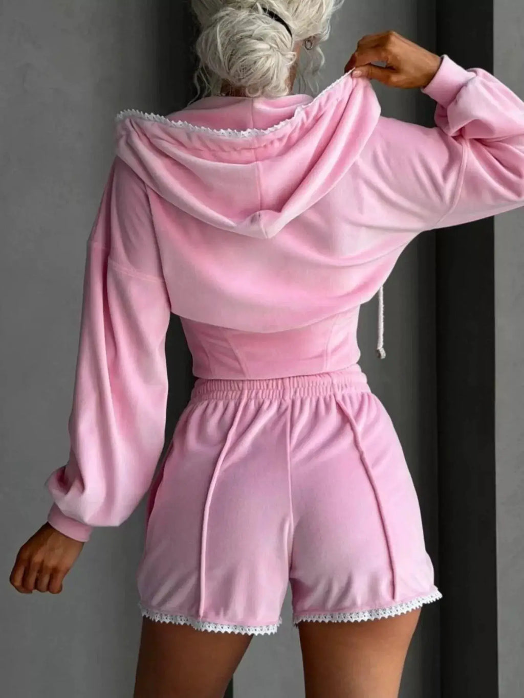 Pink two-piece zip-up hooded activewear set with shorts; hoodie features white lace trim and drawstrings