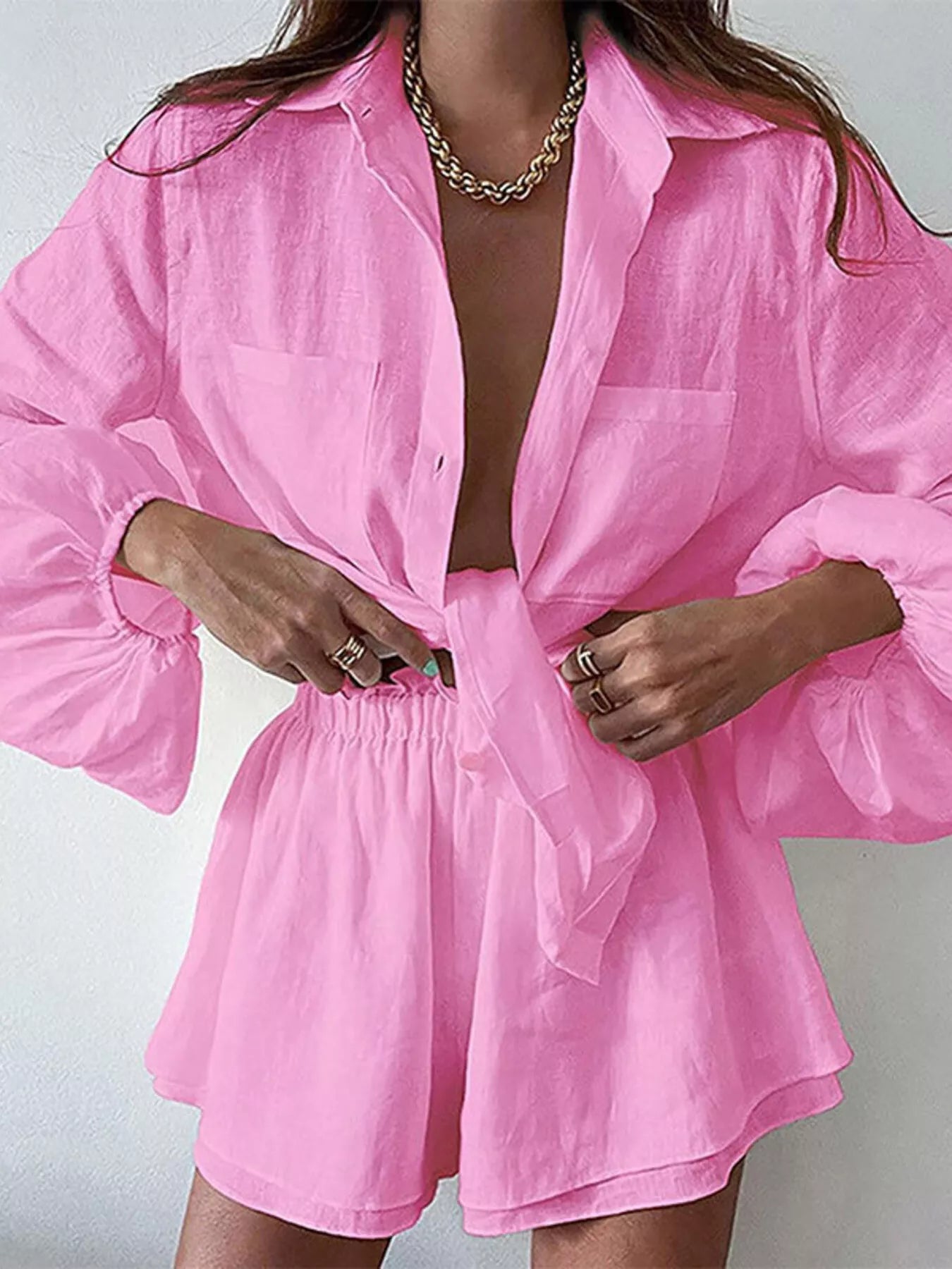 Pink button-up long-sleeve shirt and shorts set; tie-front top with relaxed fit.