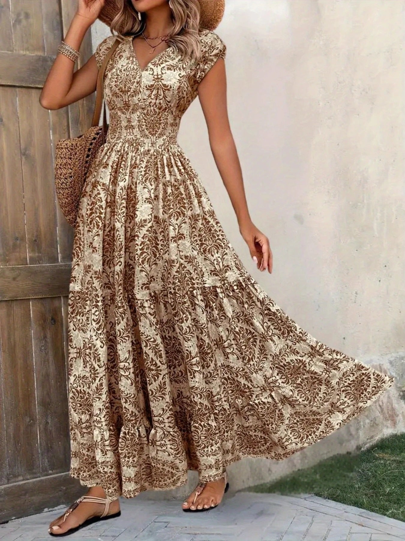 Printed cap-sleeve maxi dress with beige/brown floral pattern; tiered skirt and smocked bodice