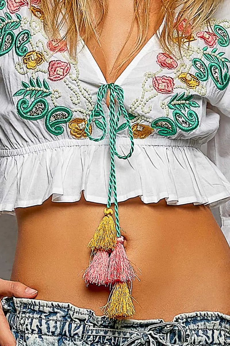 POL Floral Embroidered Cropped Blouse with green tassel tie on white fabric.