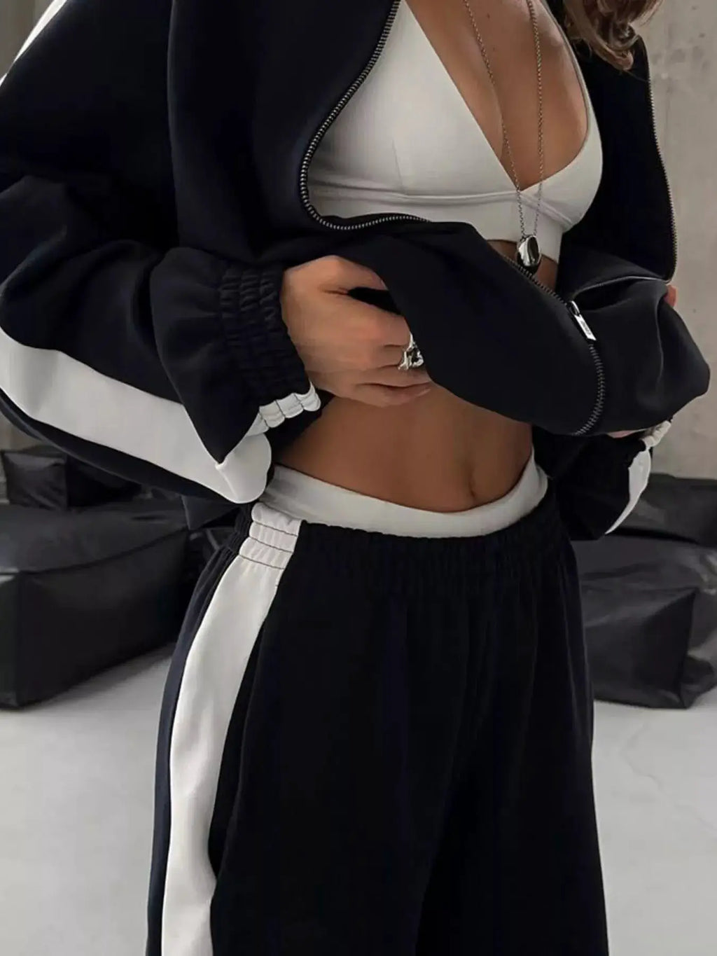 Belle Bijouix two-piece zip-up activewear set; black jacket with white side panels and matching pants.