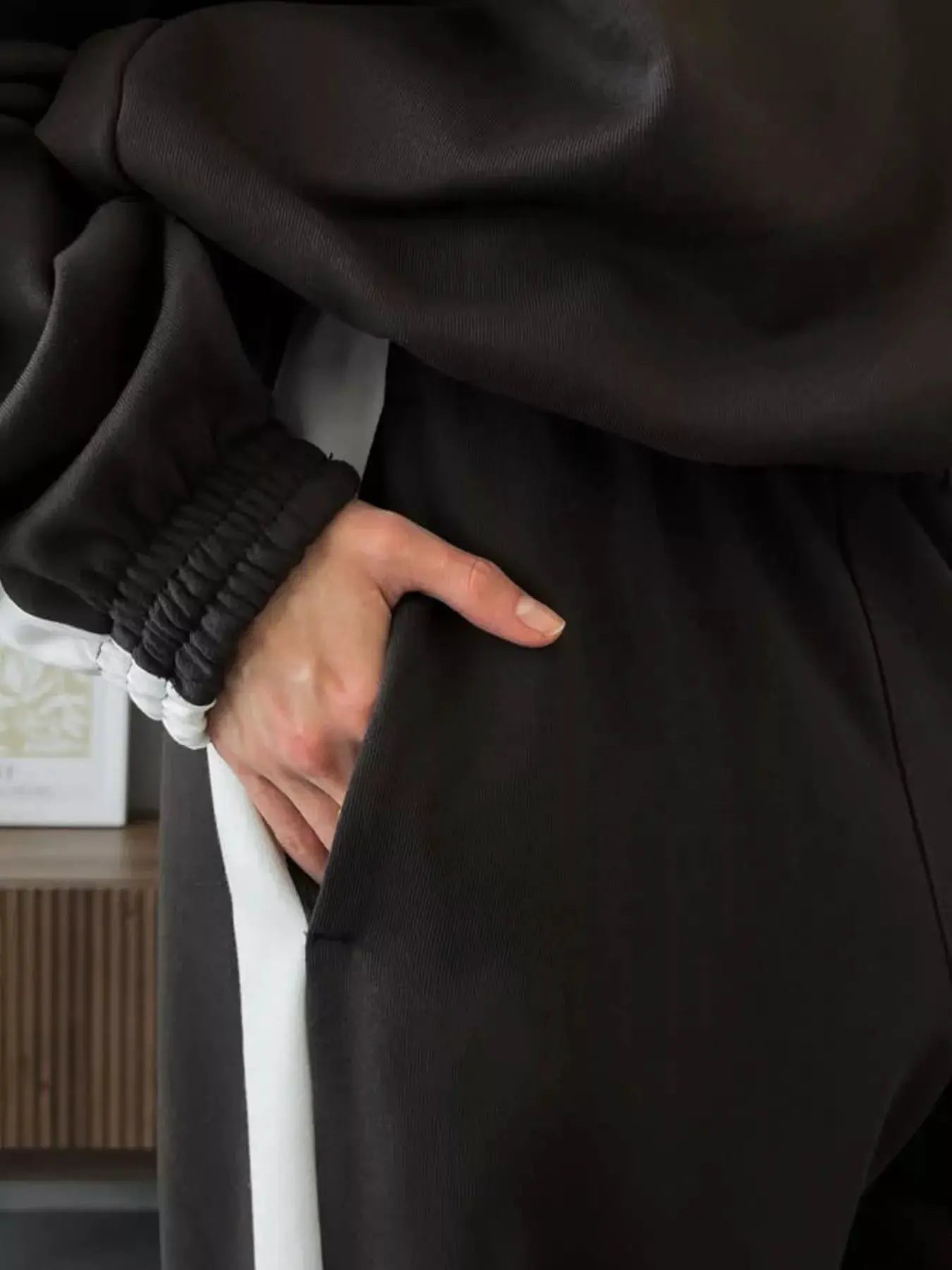 Two-Piece black zip-up activewear set with white side stripe; hoodie and pants.