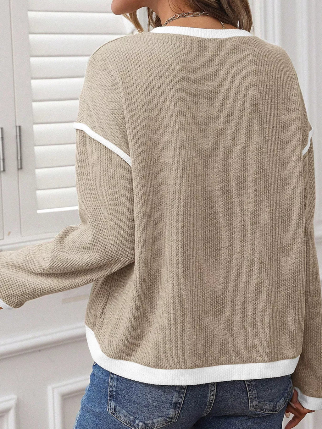 Beige knit drop-shoulder loose top with white contrast trim at cuffs and hem