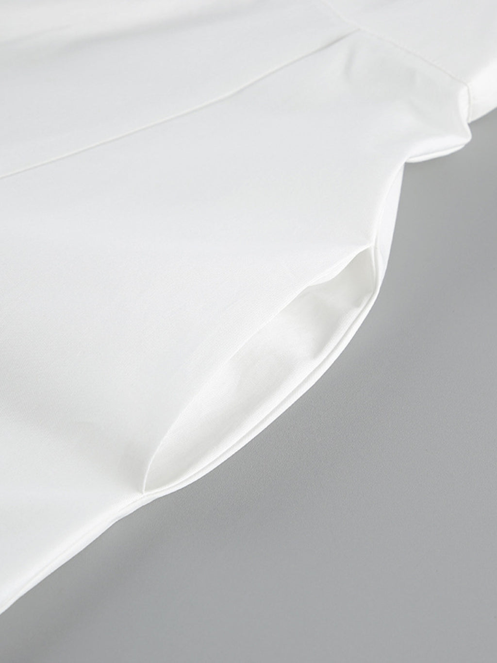Backless sleeveless button-front maxi dress, white fabric close-up