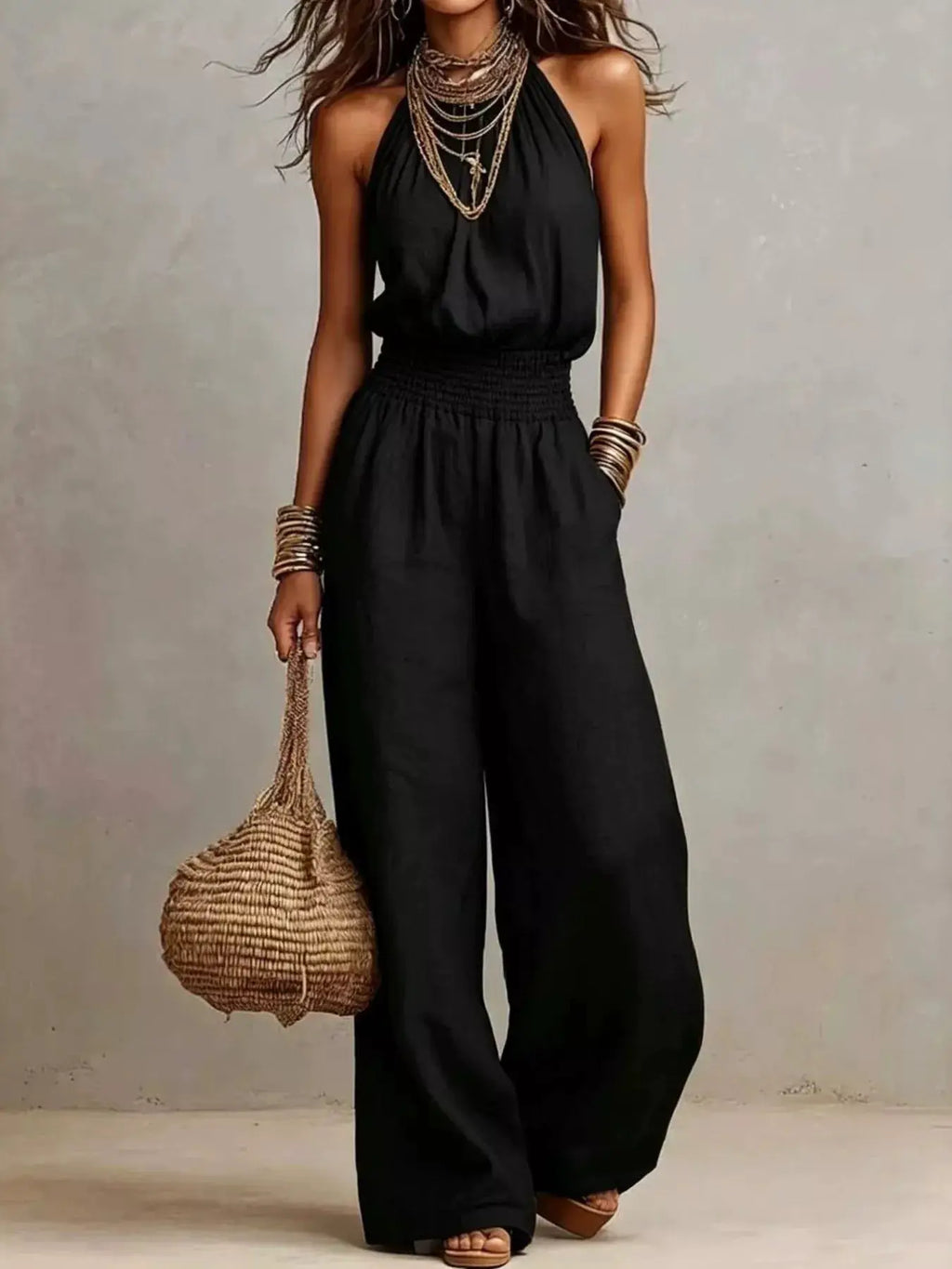 Smocked halter-neck wide-leg jumpsuit in black with smocked waist.