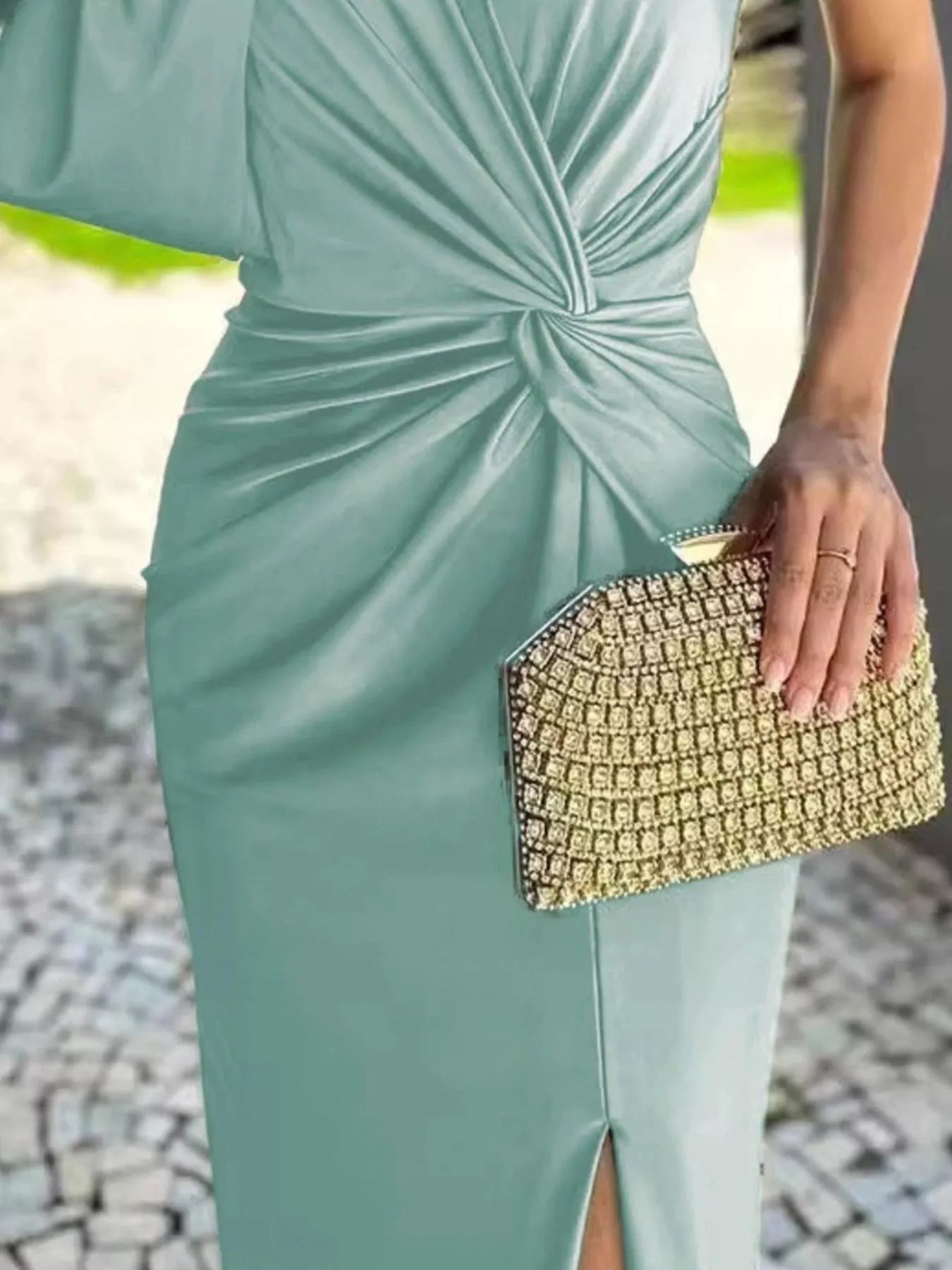 Full Size One-Shoulder Knot Detail Slit Maxi Dress; Trendsi teal plus-size with side slit and beige patterned clutch.