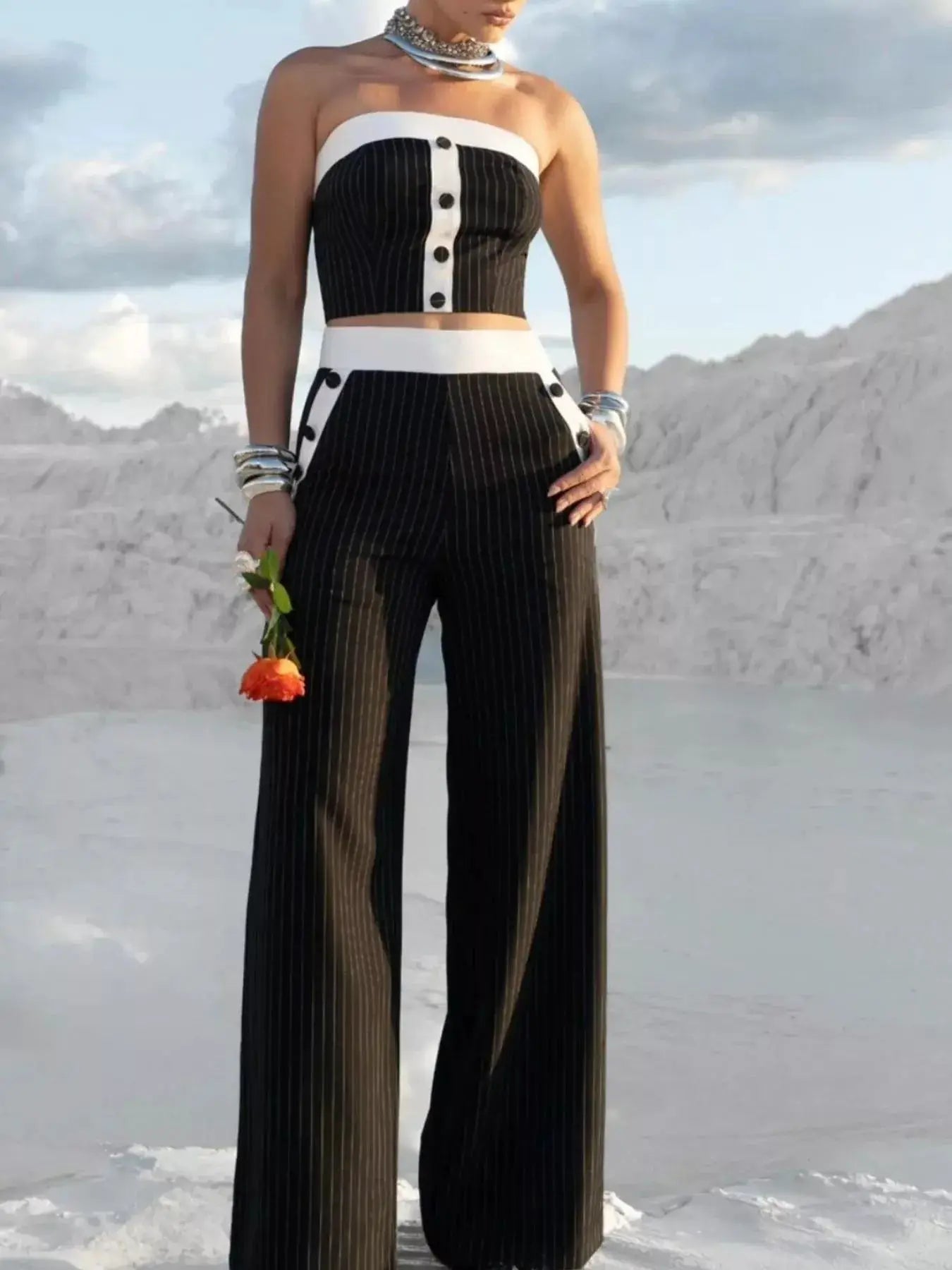 Pinstriped strapless crop top and wide-leg pants set in black with white trim and front button detail.