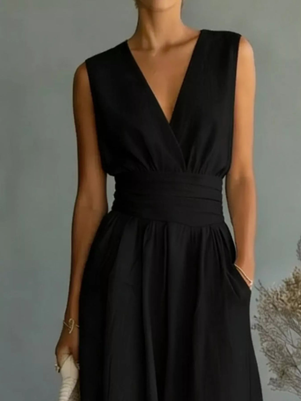 Plus-size black sleeveless jumpsuit with V-neck wrap top and wide-leg pants by Trendsi