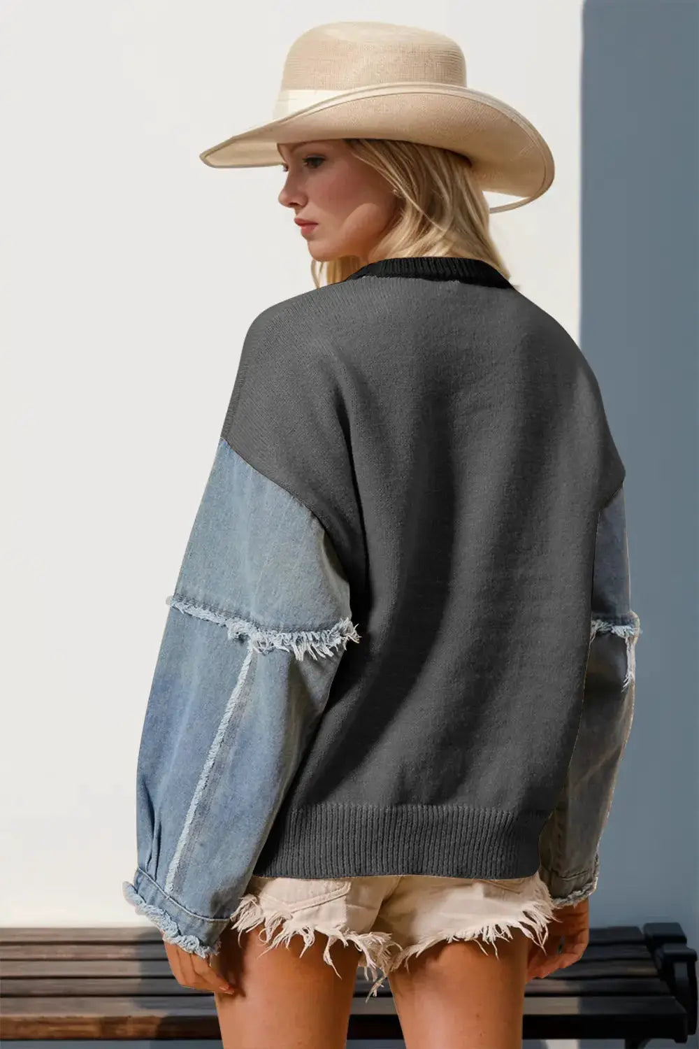 Sweater with dark gray body and light denim sleeves with frayed edges.
